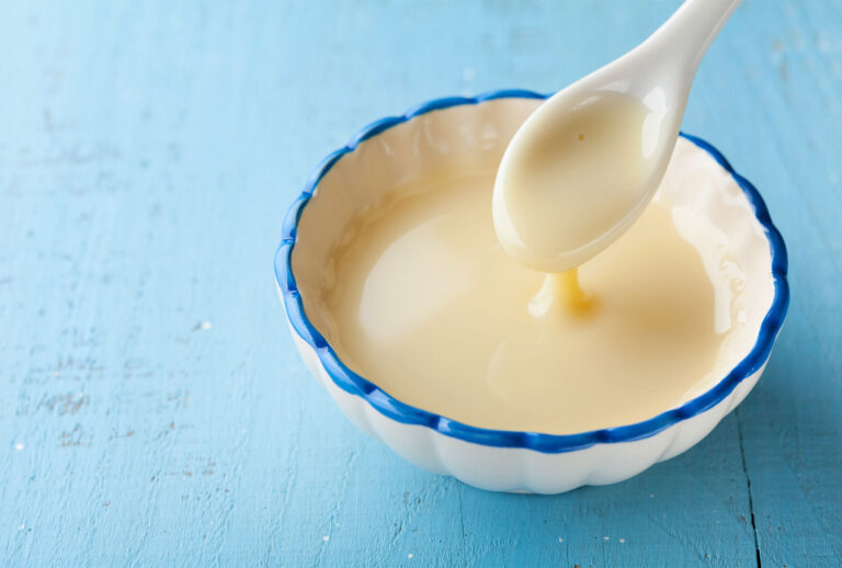 Bowl with pouring condensed milk (Getty Images/Julia Sudnitskaya)