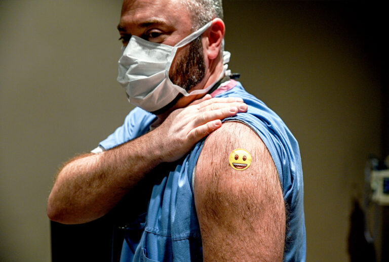 Dr. Jason Smith displays his bandage after being administered a COVID-19 vaccination at University of Louisville Hospital on December 14, 2020 in Louisville, Kentucky. The Pfizer-BioNTech vaccine became available for specified use on Monday morning to five members of hospital staff. Dr. Smith became the first recipient of the vaccine in the state of Kentucky. (Jon Cherry/Getty Images)