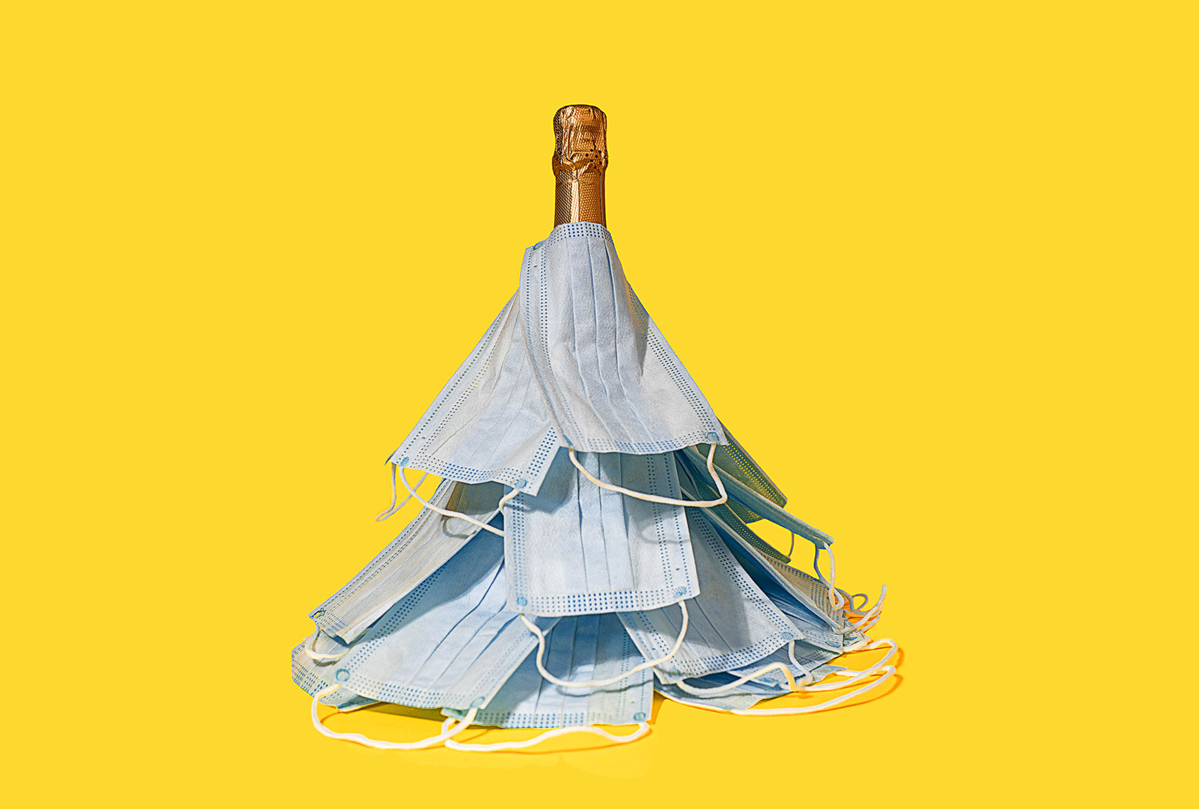 Medical masks laid out in the shape of a Christmas tree on a bottle of champagne (Getty Images)