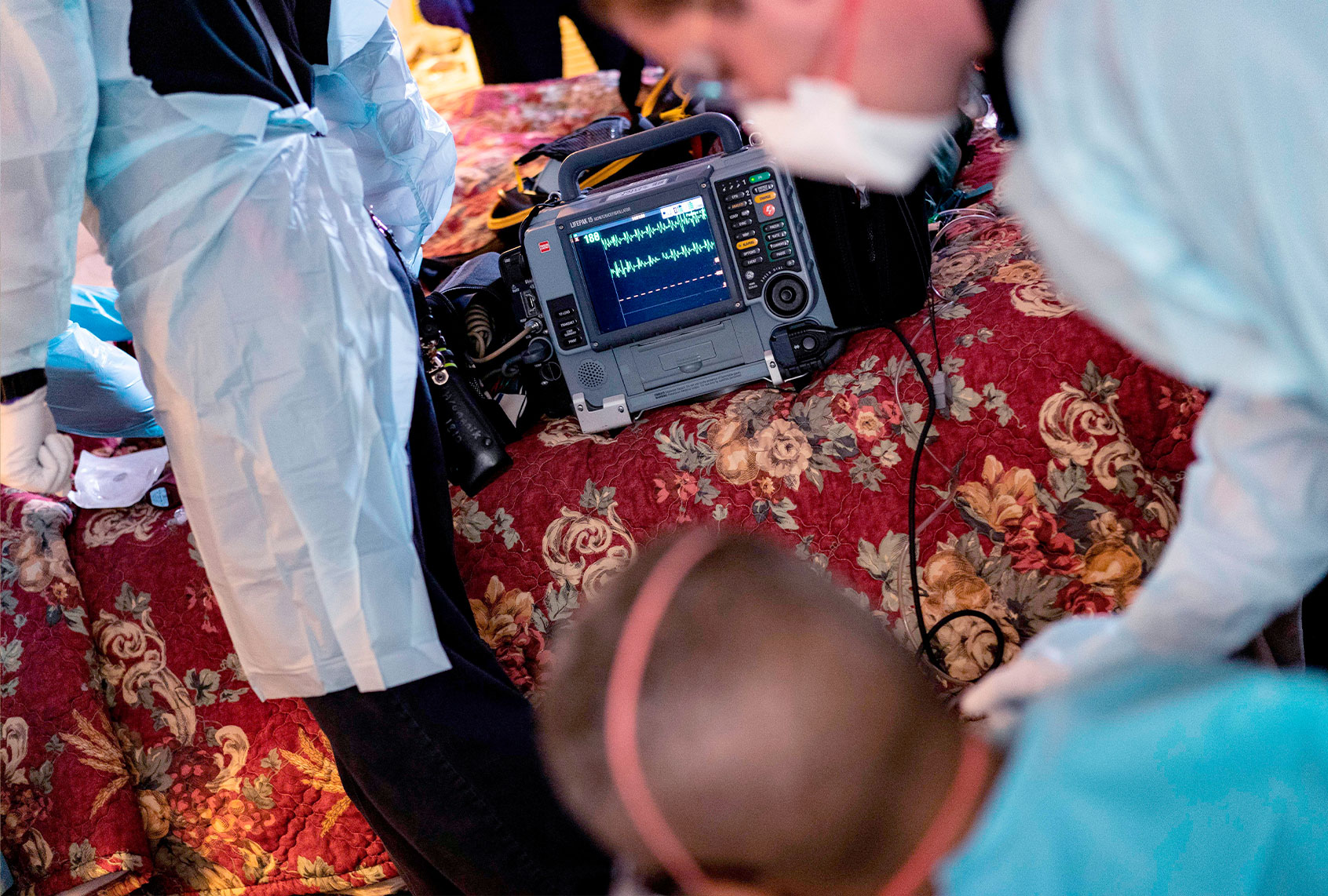 Firefighters and paramedics with Anne Arundel County Fire Department wear enhanced PPE, during the coronavirus pandemic, as they treat a patient in cardiac arrest as a result of a drug overdose on May 6, 2020, in Brooklyn, Maryland. (ALEX EDELMAN/AFP via Getty Images)