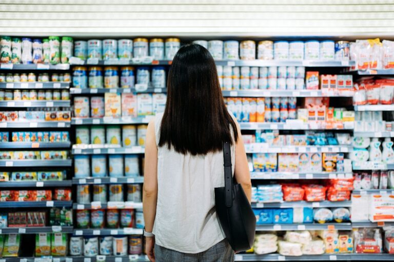 Rear view of young mother groceries shopping for baby products in a supermarket. (Getty Images)