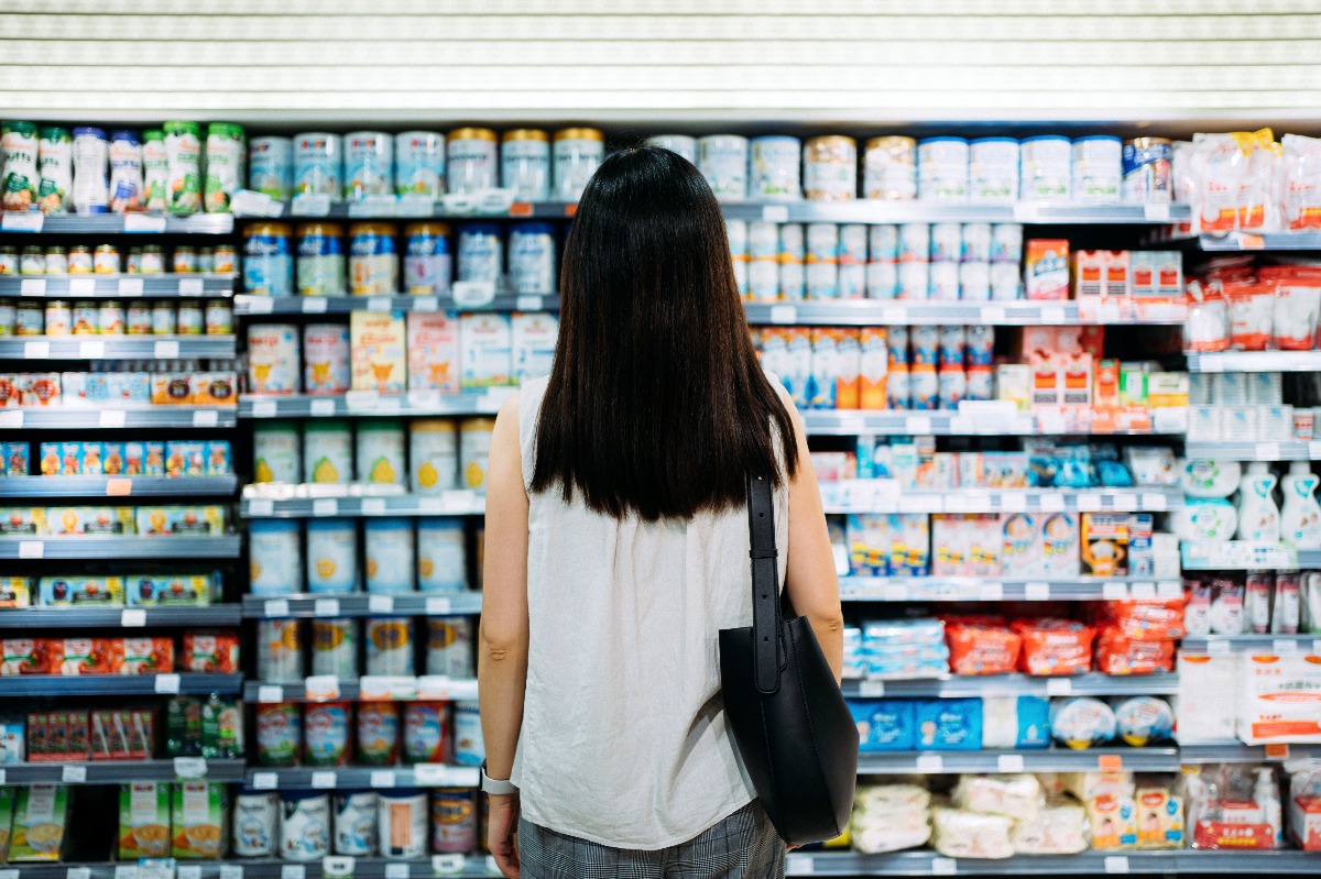 Rear view of young mother groceries shopping for baby products in a supermarket. (Getty Images)