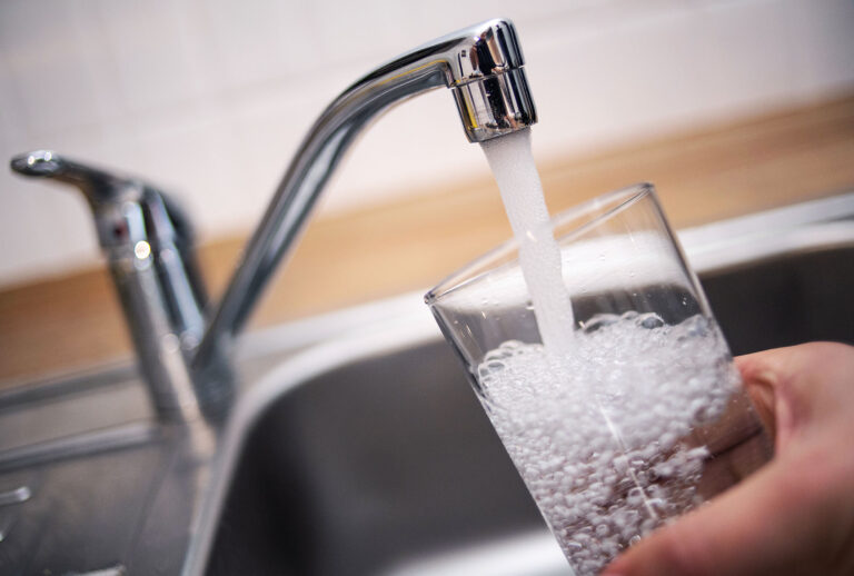 A man holds a glass under a running tap. (Marius Becker/picture alliance via Getty Images)