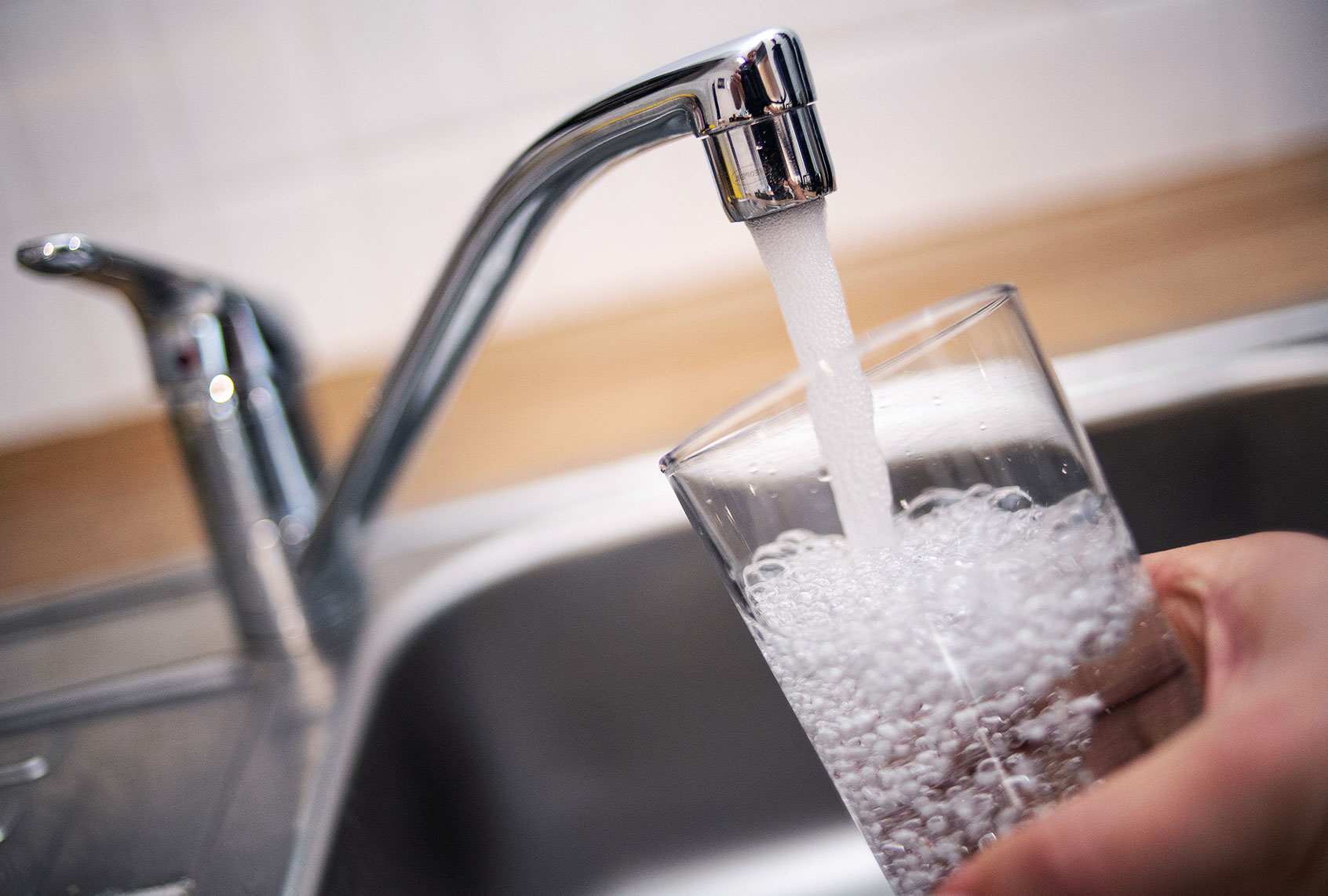 A man holds a glass under a running tap. (Marius Becker/picture alliance via Getty Images)