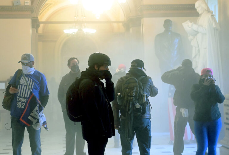 Supporters of US President Donald Trump enter the US Capitol as tear gas fills the corridor on January 6, 2021, in Washington, DC. - Demonstrators breeched security and entered the Capitol as Congress debated the a 2020 presidential election Electoral Vote Certification. (SAUL LOEB/AFP via Getty Images)