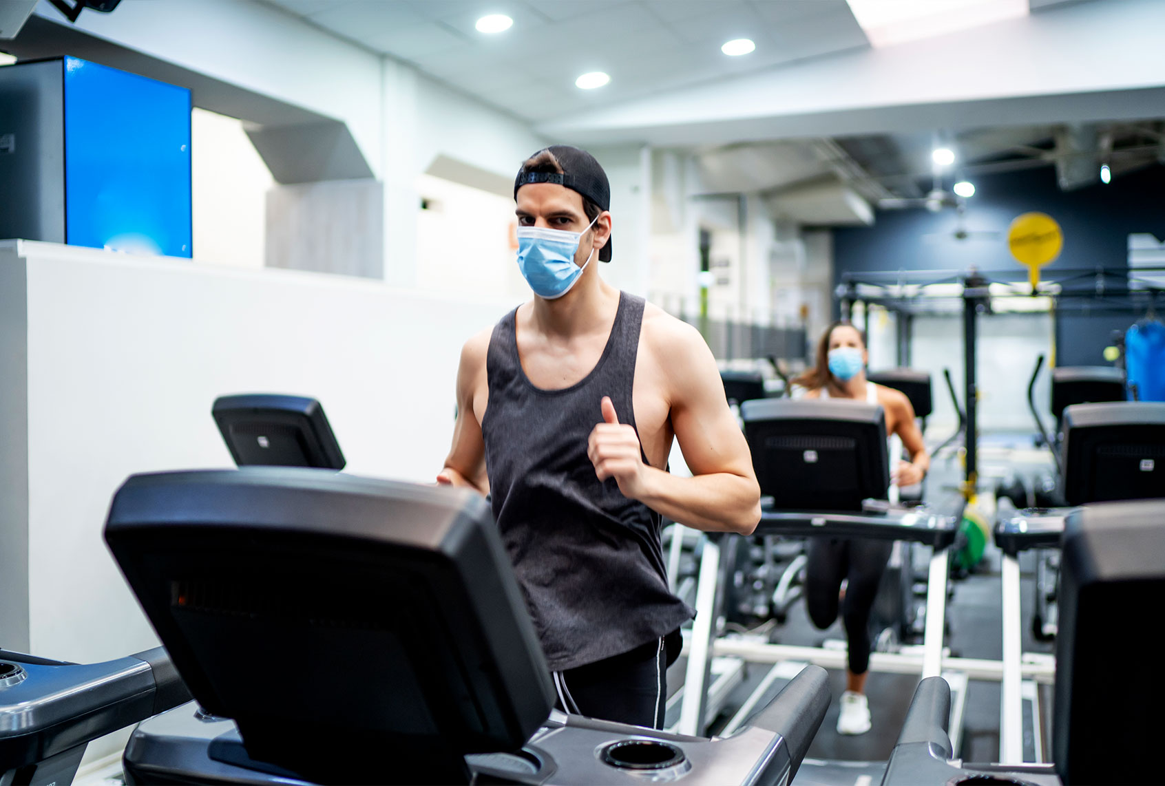 Several young people running on treadmill in gym wearing face mask (Getty Images)