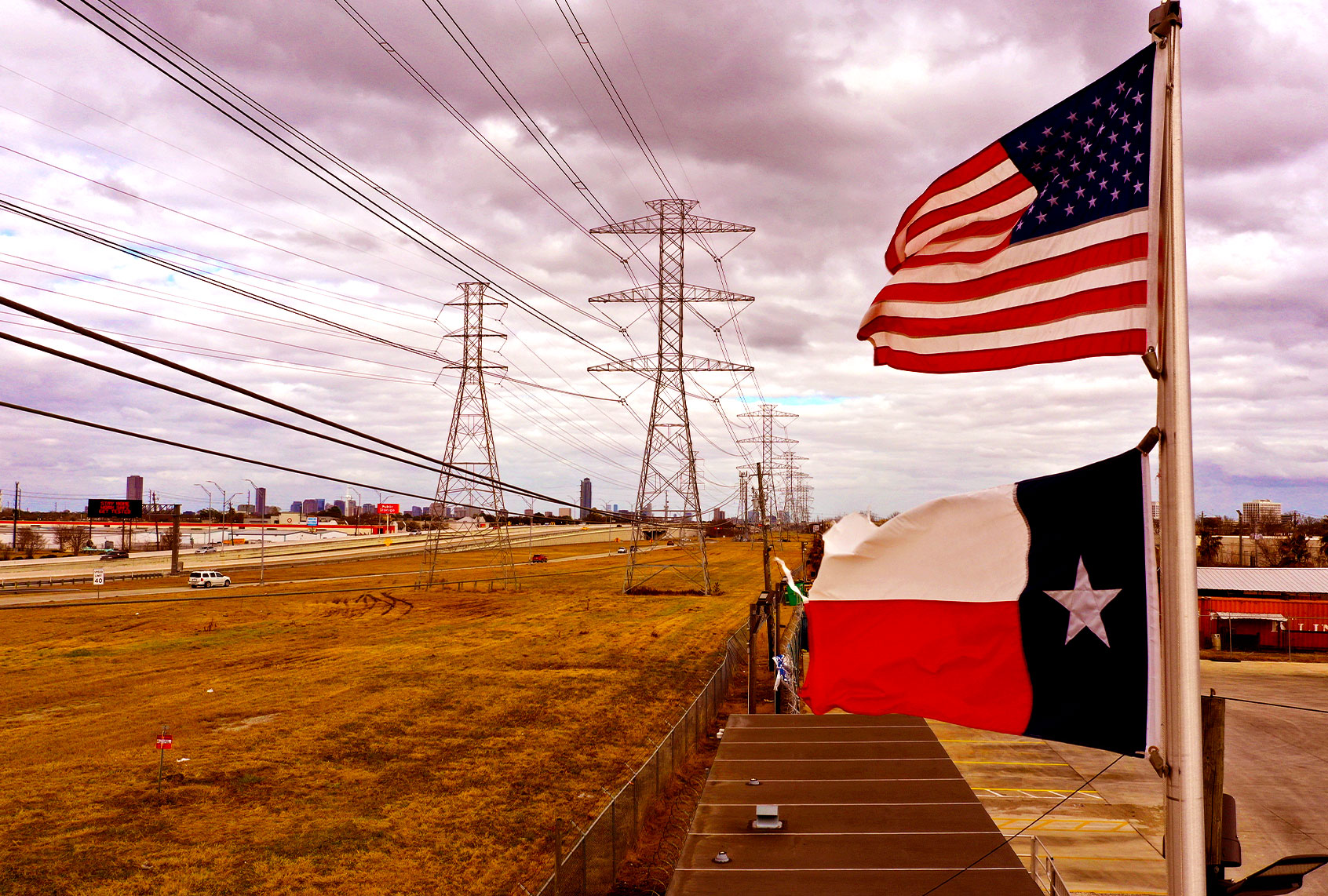 The U.S. and Texas flags fly in front of high voltage transmission towers on February 21, 2021 in Houston, Texas. Millions of Texans lost power when winter storm Uri hit the state and knocked out coal, natural gas and nuclear plants that were unprepared for the freezing temperatures brought on by the storm. Wind turbines that provide an estimated 24 percent of energy to the state became inoperable when they froze. (Justin Sullivan/Getty Images)