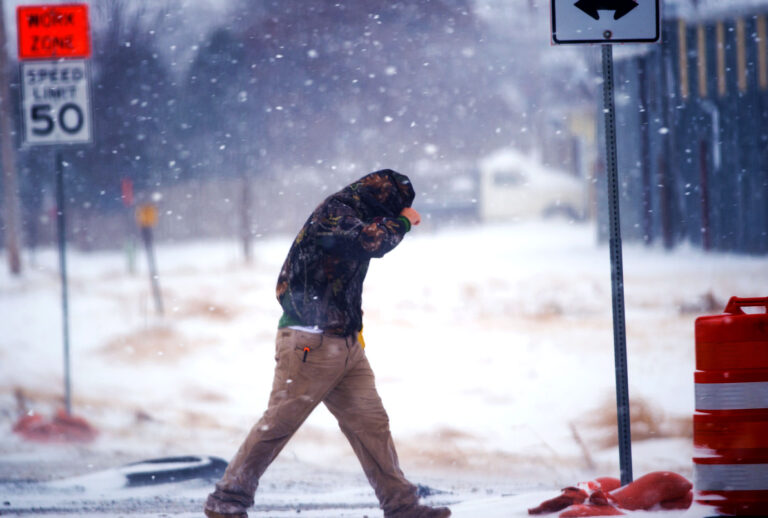 A highway worker tries to shield himself while walking to his truck in Lubbock, Texas. (John Weast/Getty Images)
