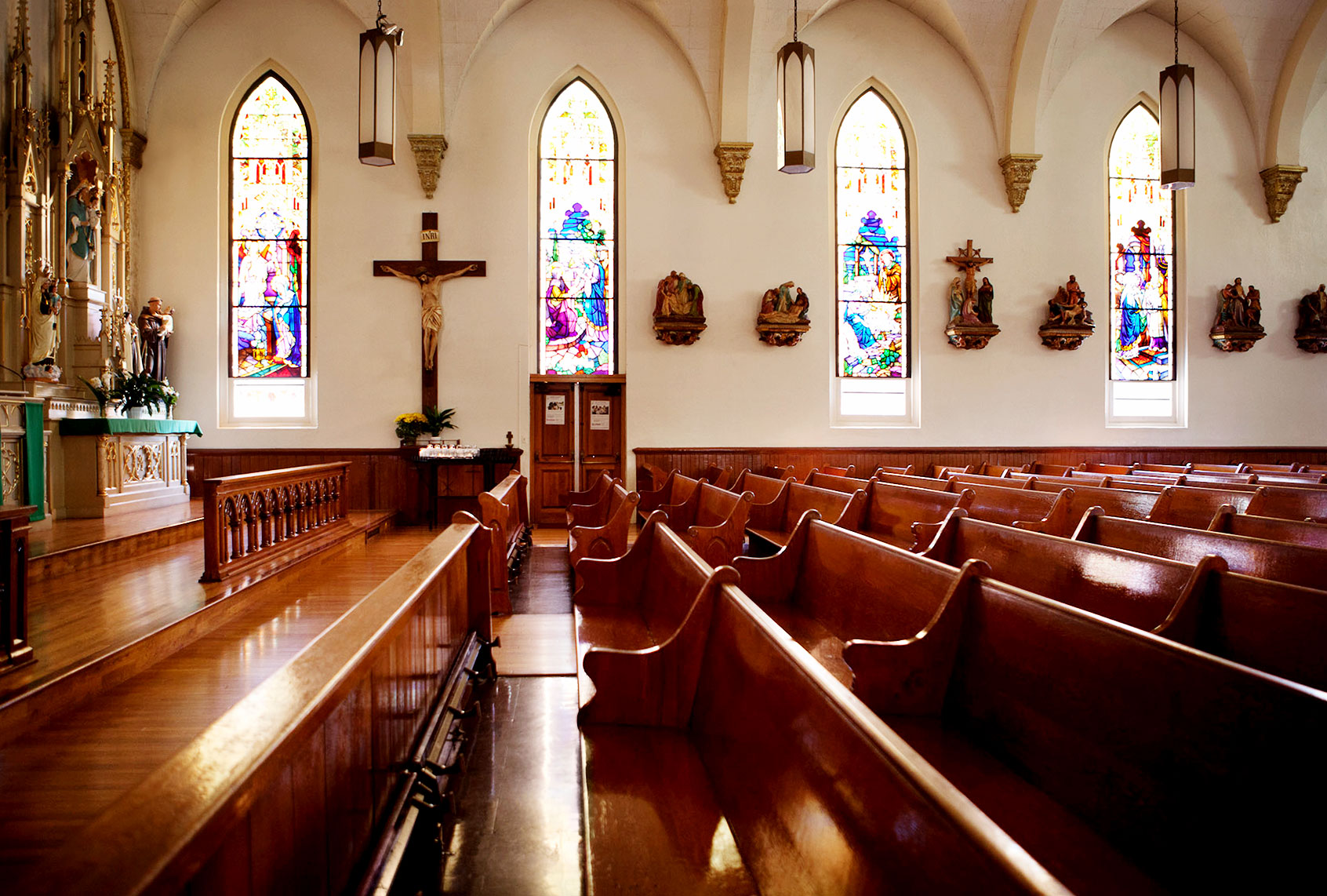 Empty pews and stained glass windows in church (Getty Images/	Monashee Frantz)