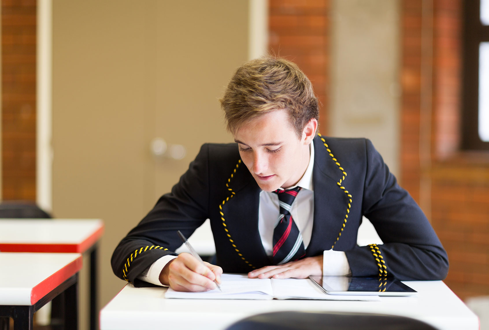 High school boy in uniform in classroom (Getty Images)