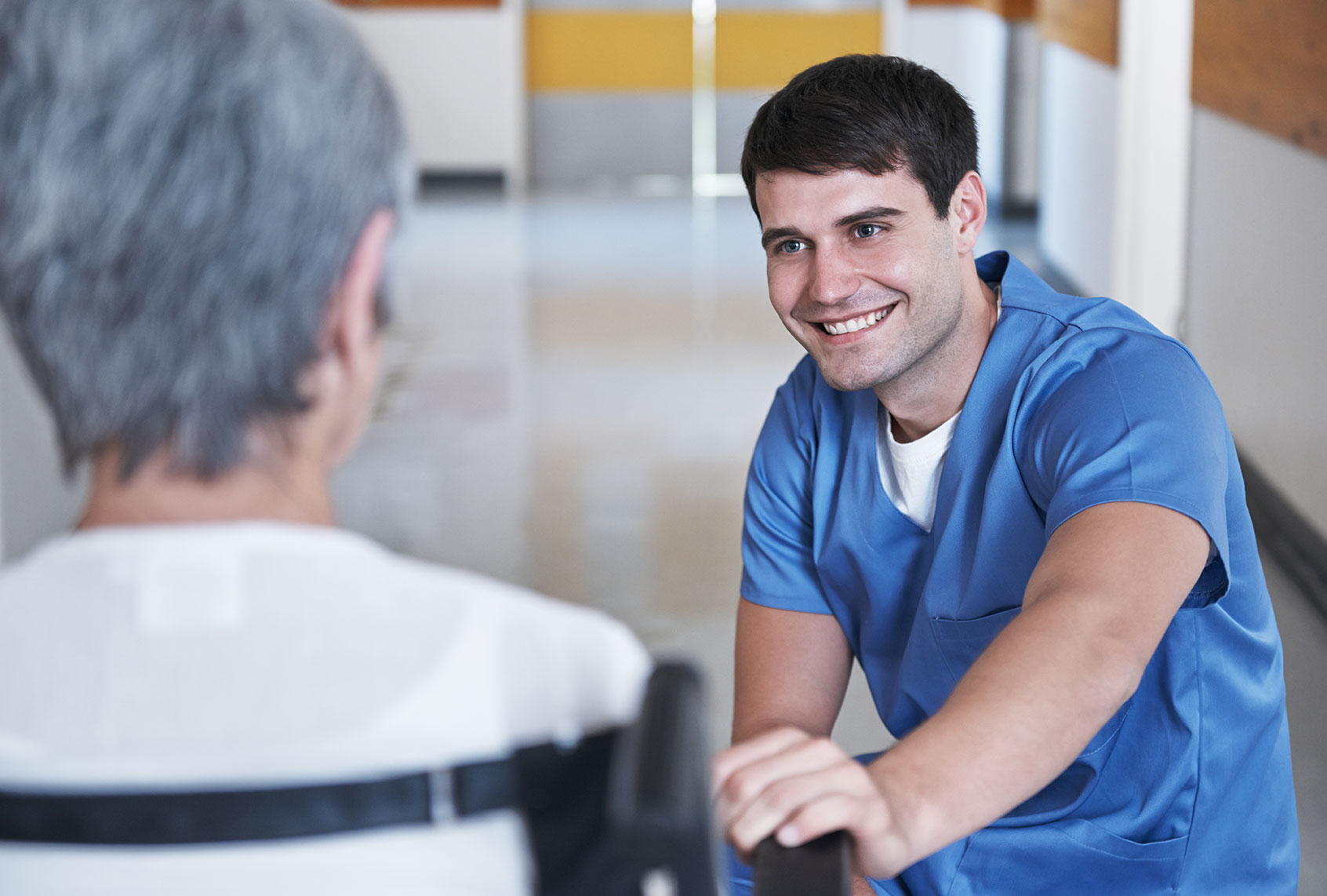 Young male nurse caring for an elderly patient in a wheelchair (Getty Images)