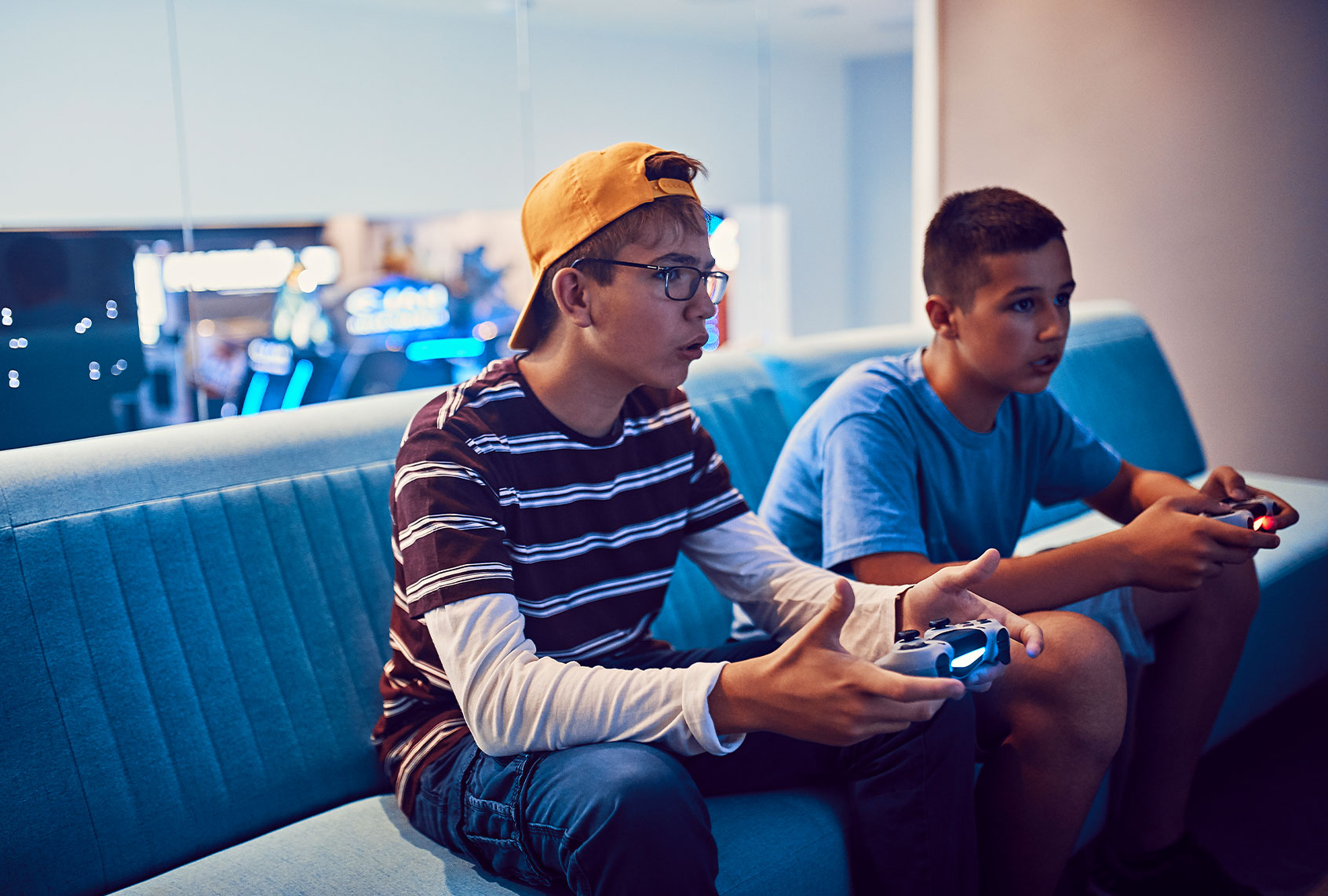 Teenage friends playing video game in an amusement arcade (Getty Images)
