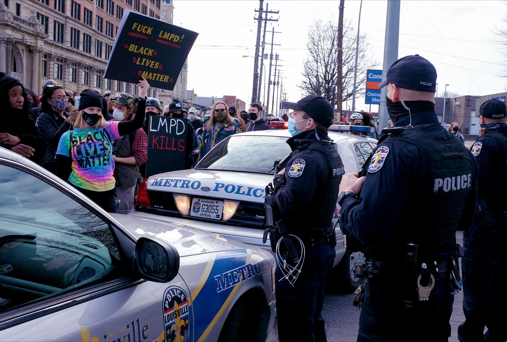 A protestor holds an anti-LMPD sign in front of Louisville Metro Police Department officers during a rally in remembrance of the one year anniversary of the death of Breonna Taylor in Louisville, Kentucky on March 13, 2021. - Twelve months after the killing -- in which police shot Taylor while looking for a former friend of hers -- only one of three police officers has been charged, and only for endangering Taylor's neighbors by firing wildly. (JEFF DEAN/AFP via Getty Images)