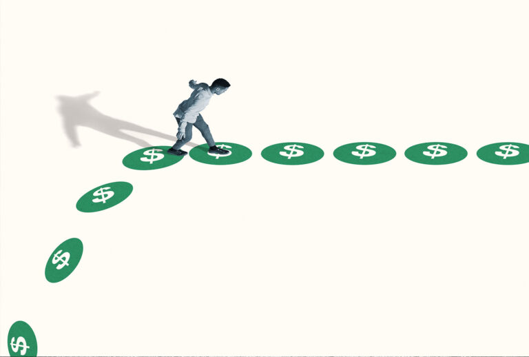 High angle side view of watchful young man walking on green dollar signs against white background (Getty Images)