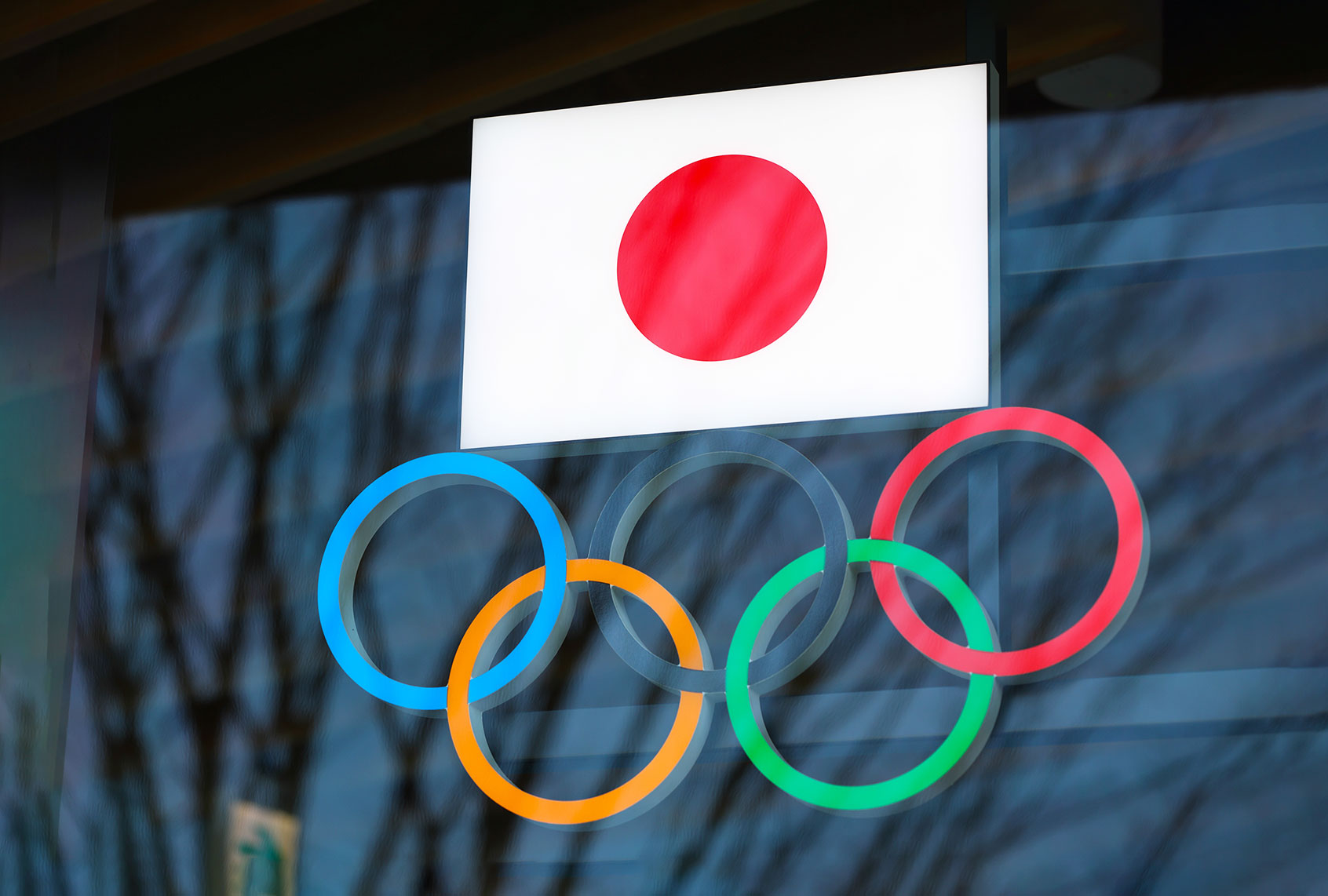 Japanese flag with Olympic Rings above the entrance to Japan Olympic Museum in Shinjuku. Due to the Coronavirus pandemic, the Tokyo 2020 Olympic Games were moved to be held between 7.23 - 8.8, 2021. (Stanislav Kogiku/SOPA Images/LightRocket via Getty Images)
