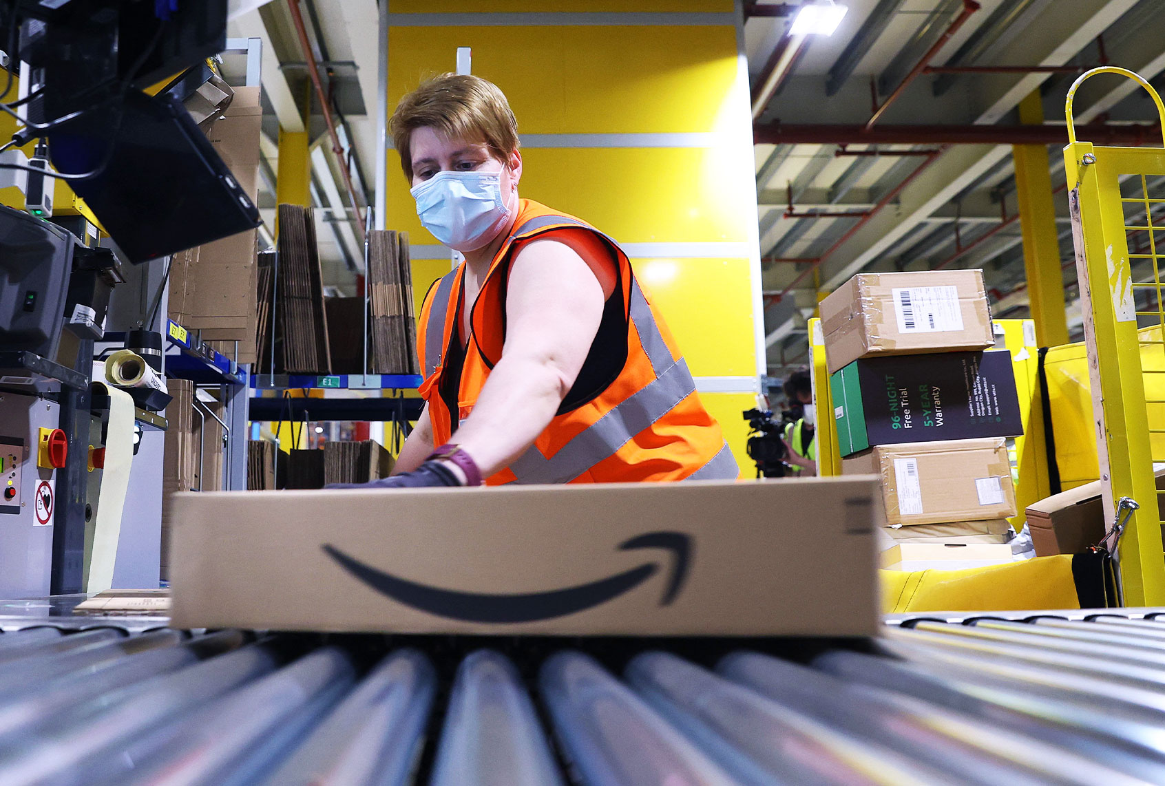 An Amazon employee prepares a package for shipment (RONNY HARTMANN/AFP via Getty Images)