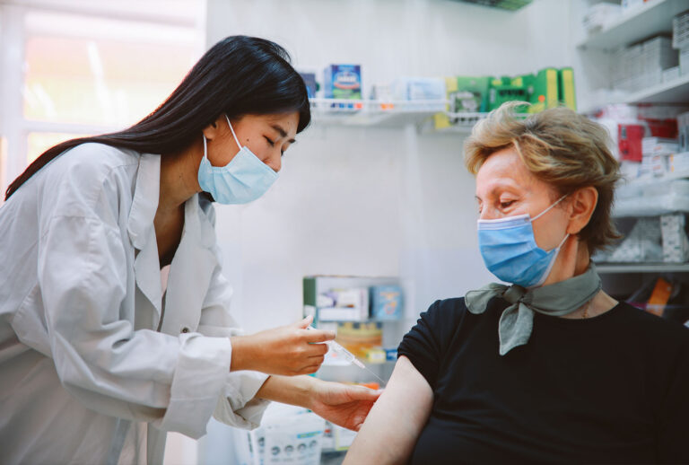 Nurse giving flu vaccine to a senior patient (Getty Images)