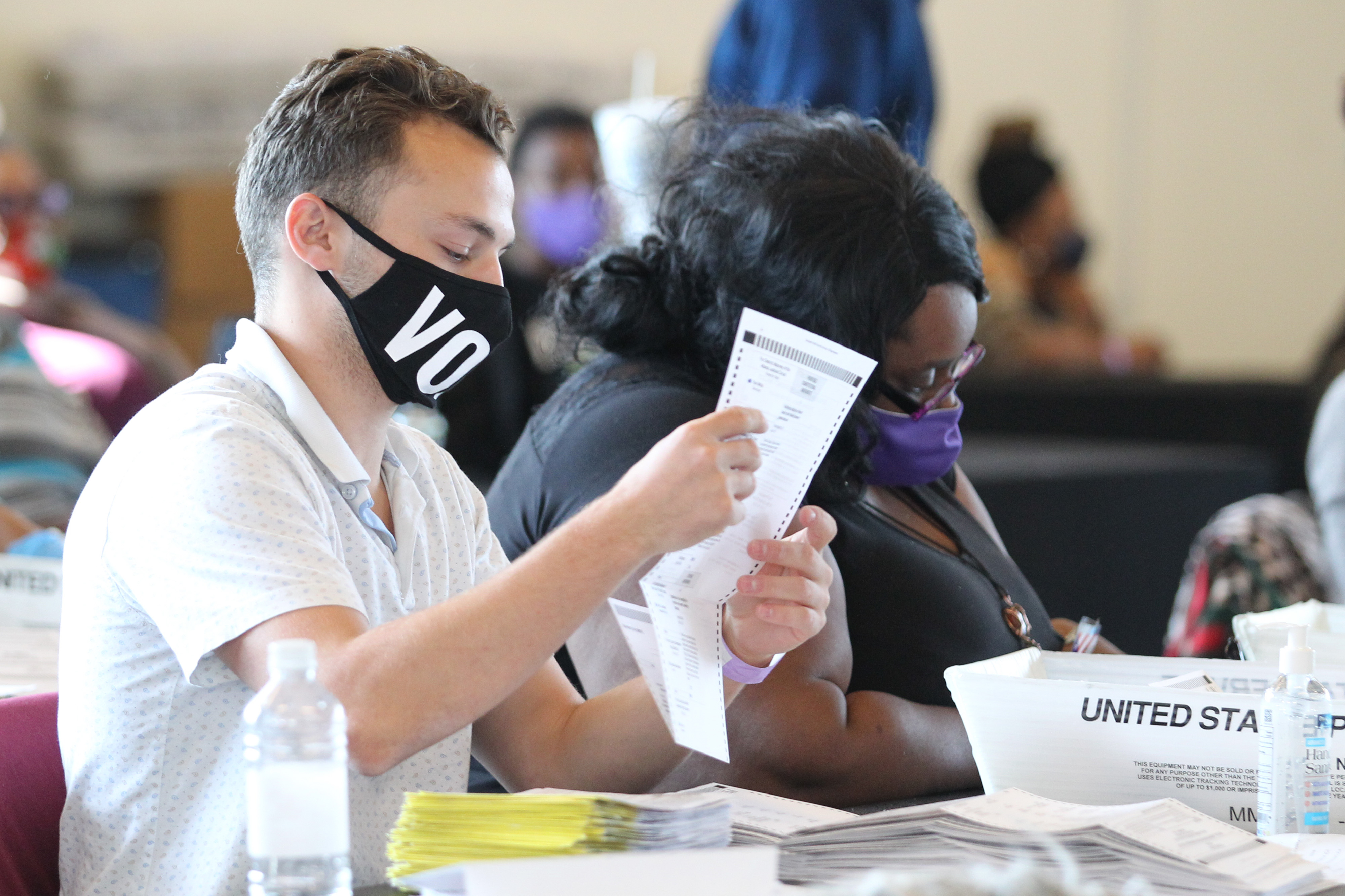 Fulton County election workers examine ballots while vote counting at State Farm Arena on Nov. 5, 2020, in Atlanta, Georgia. (TAMI CHAPPELL/AFP via Getty Images)