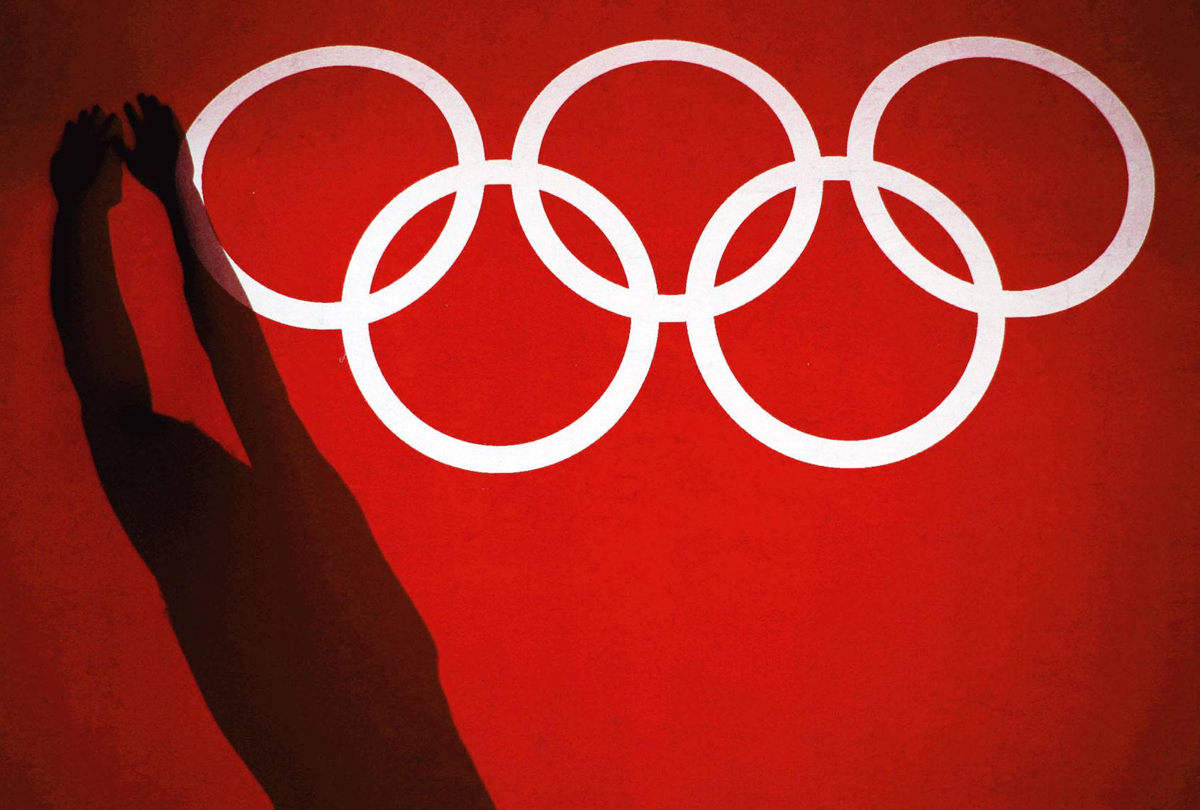 Shaddow of USA swimmer stretching next to the Olympic Rings before entering the pool for practice. (Photo illustration by Salon/Donald Miralle/Getty Images)