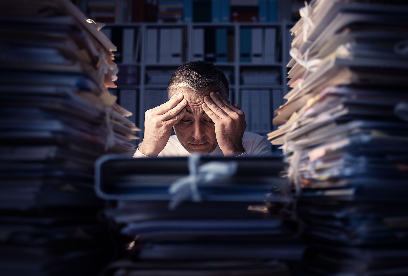 Desperate businessman working in the office late at night and overloaded with work (Getty Images)