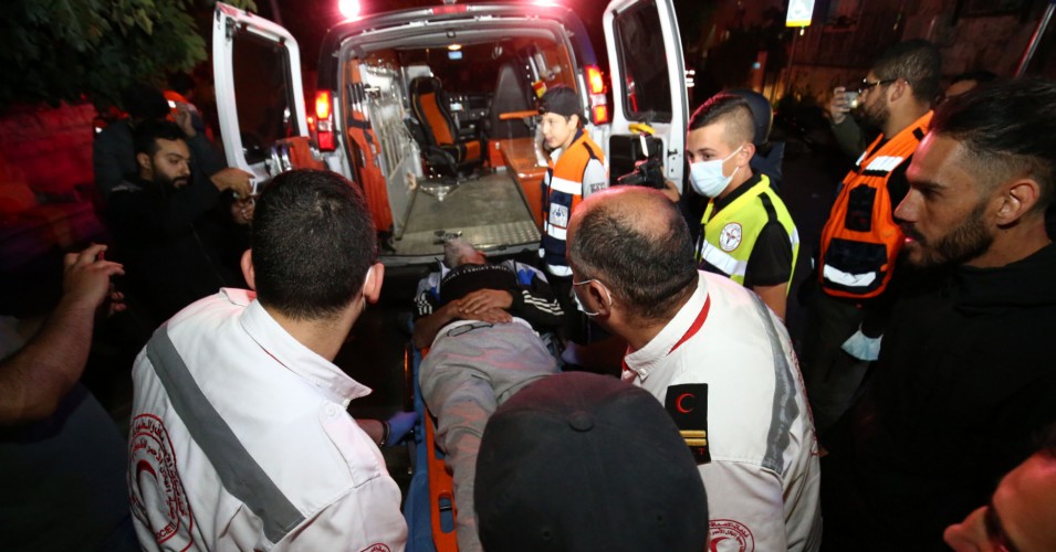 Injured Palestinian Salih Diyab is carried to an ambulance after Israeli forces cracked down on demonstrations against the forced eviction of Palestinian families from their homes in East Jerusalem's Sheikh Jarrah neighborhood on May 6, 2021. (Mostafa Alkharouf/Anadolu Agency via Getty Images)