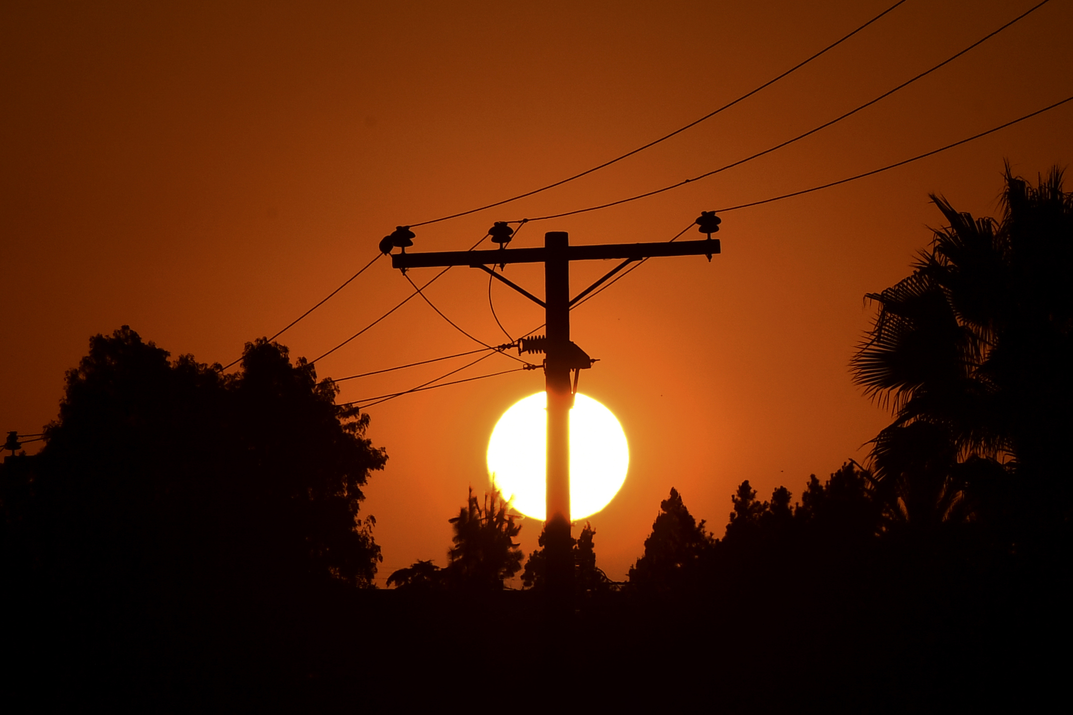 The sun sets behind power lines in Los Angeles, California. (Getty Images)
