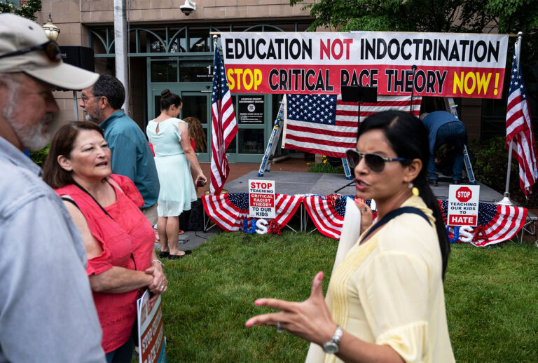 People hold up signs during a rally against "critical race theory" (CRT) being taught in schools at the Loudoun County Government center in Leesburg, Virginia on June 12, 2021. (ANDREW CABALLERO-REYNOLDS/AFP via Getty Images)