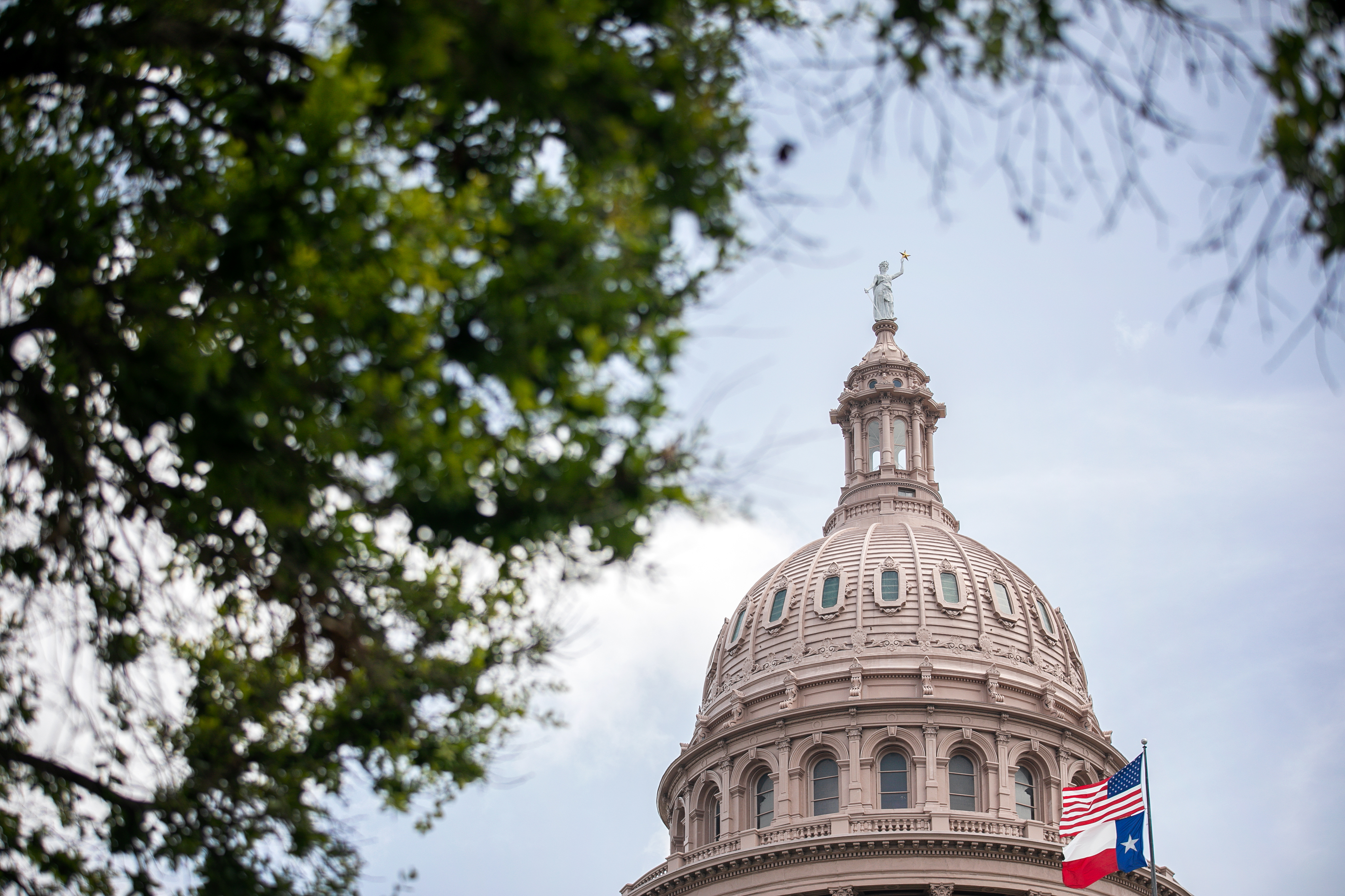 The U.S. and Texas flags wave outside the Texas Capitol on July 13, 2021 in Austin, Texas. (Montinique Monroe/Getty Images)