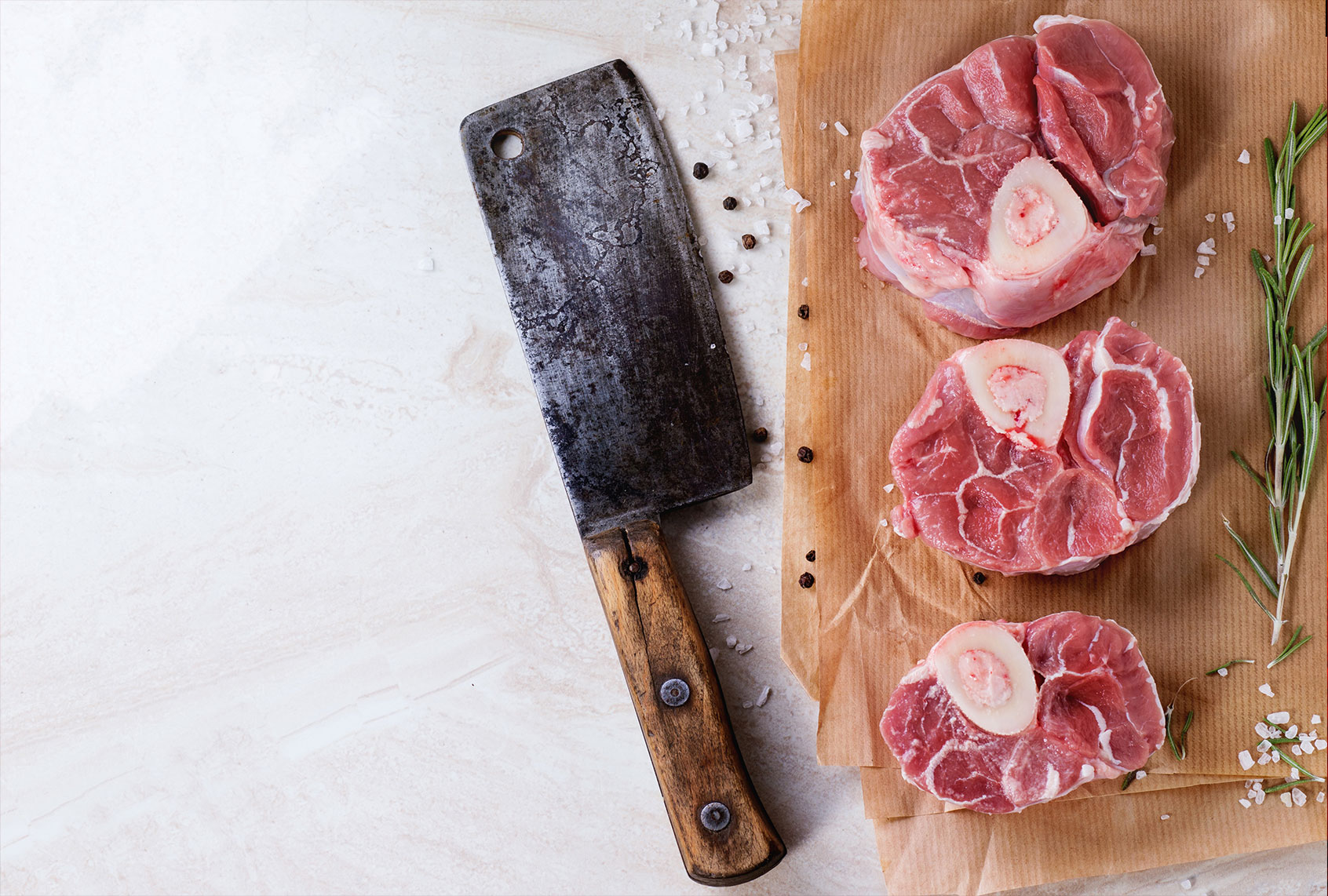 Raw osso buco meat on crumpled paper with salt, pepper and rosemary. (Natasha Breen/REDA&CO/Universal Images Group via Getty Images)