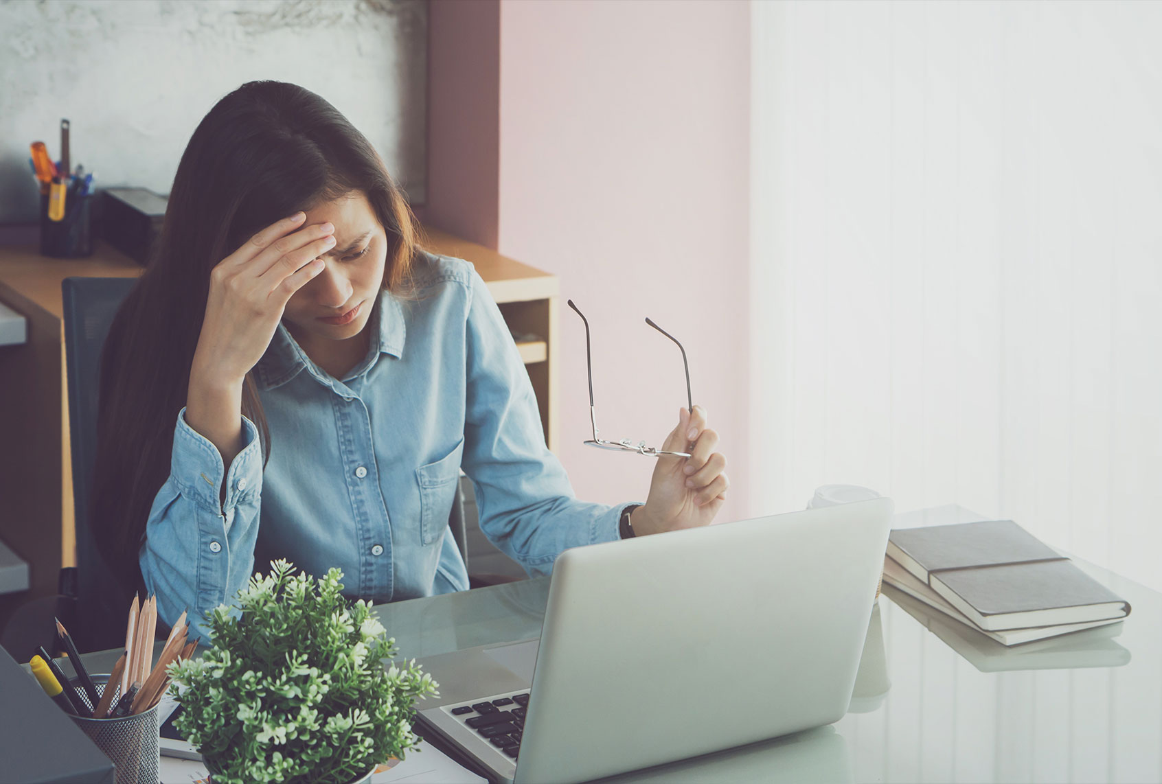 Stressed Woman By Laptop On Table (Getty Images/Bundit Binsuk)