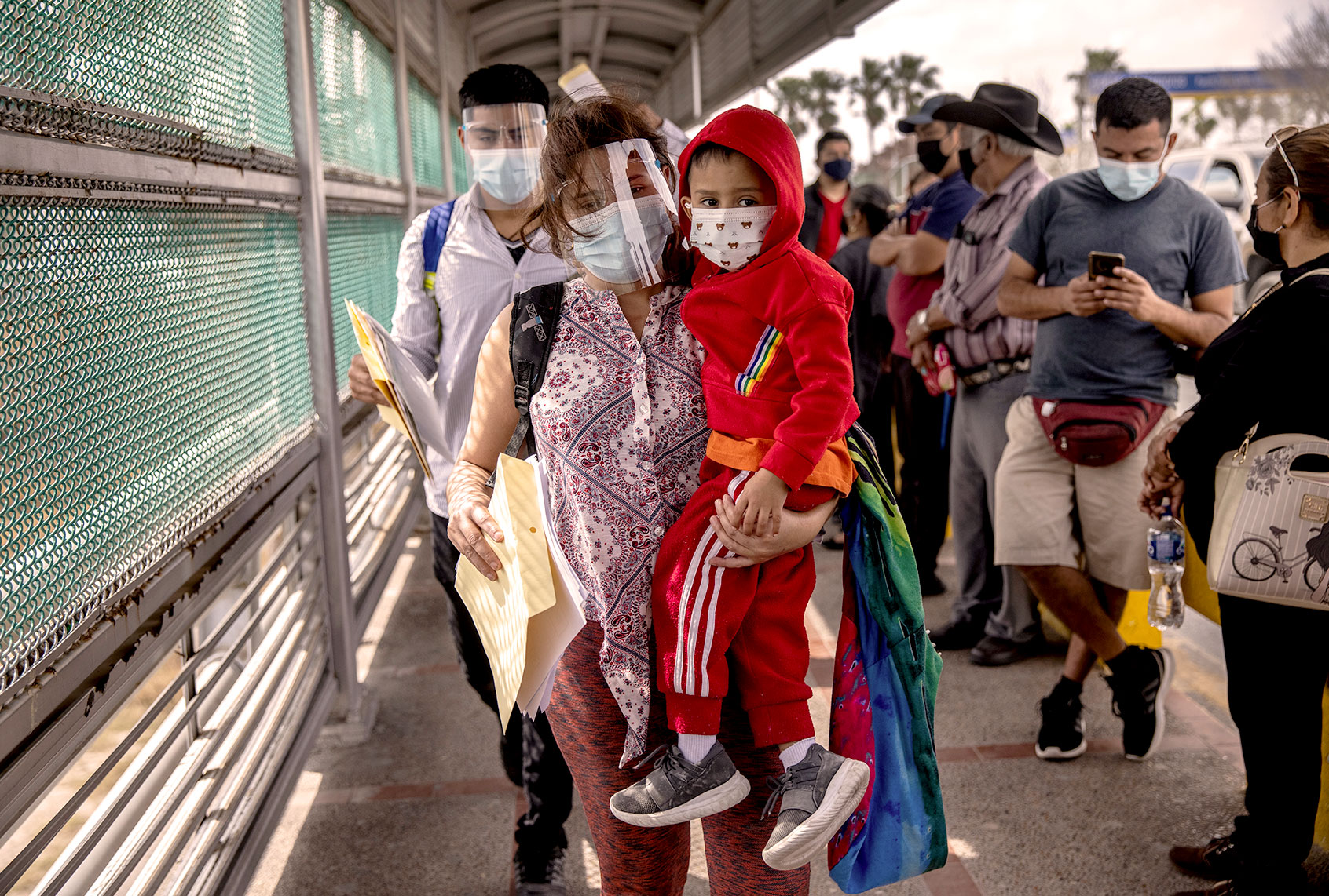 A Honduran mother carries her son, 4, across the U.S.-Mexico border as part of a group of at least 25 asylum seekers who where were allowed to travel from a migrant camp in Mexico into the United States on February 25, 2021 in Matamoros, Mexico (John Moore/Getty Images)