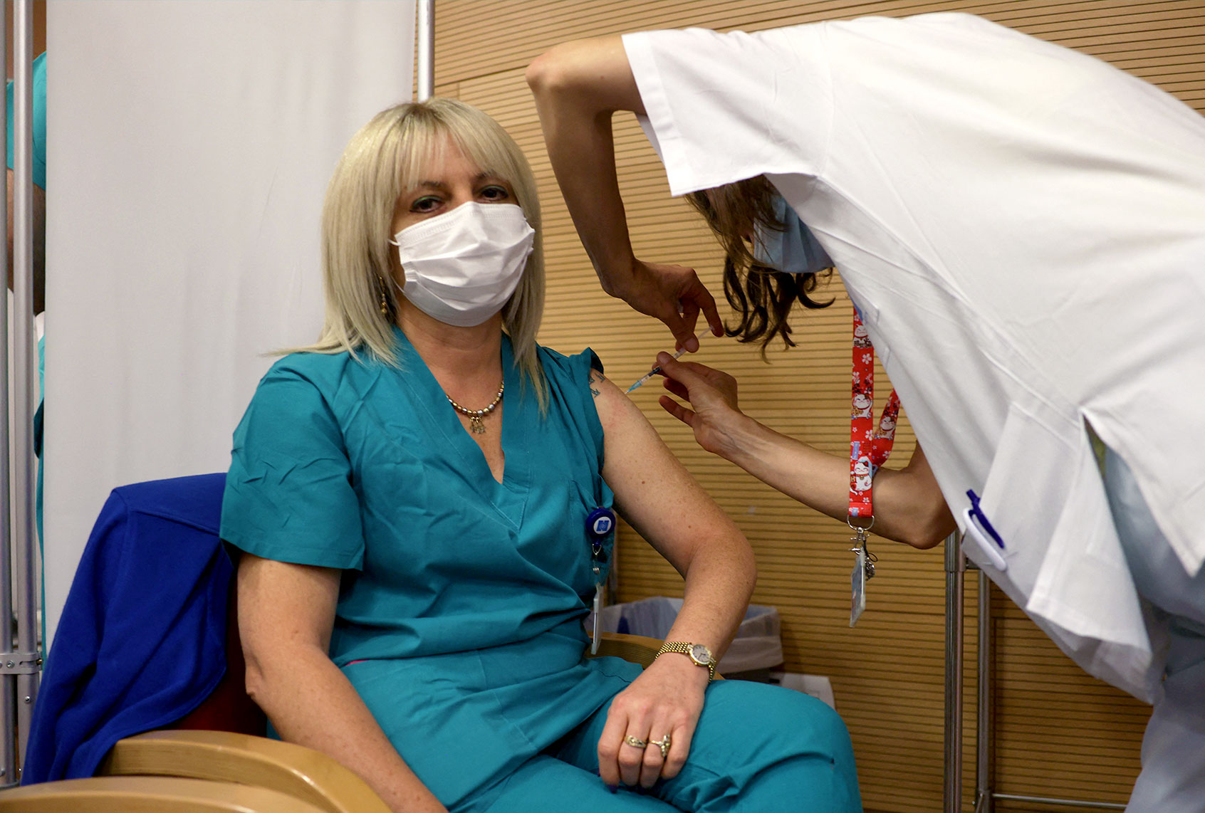 An Israeli medic administers a third booster jab of the covid vaccine to a member of medical teams, at the Hadassah Ein Kerem Hospital in Jerusalem, on August 15, 2021. (MENAHEM KAHANA/AFP via Getty Images)