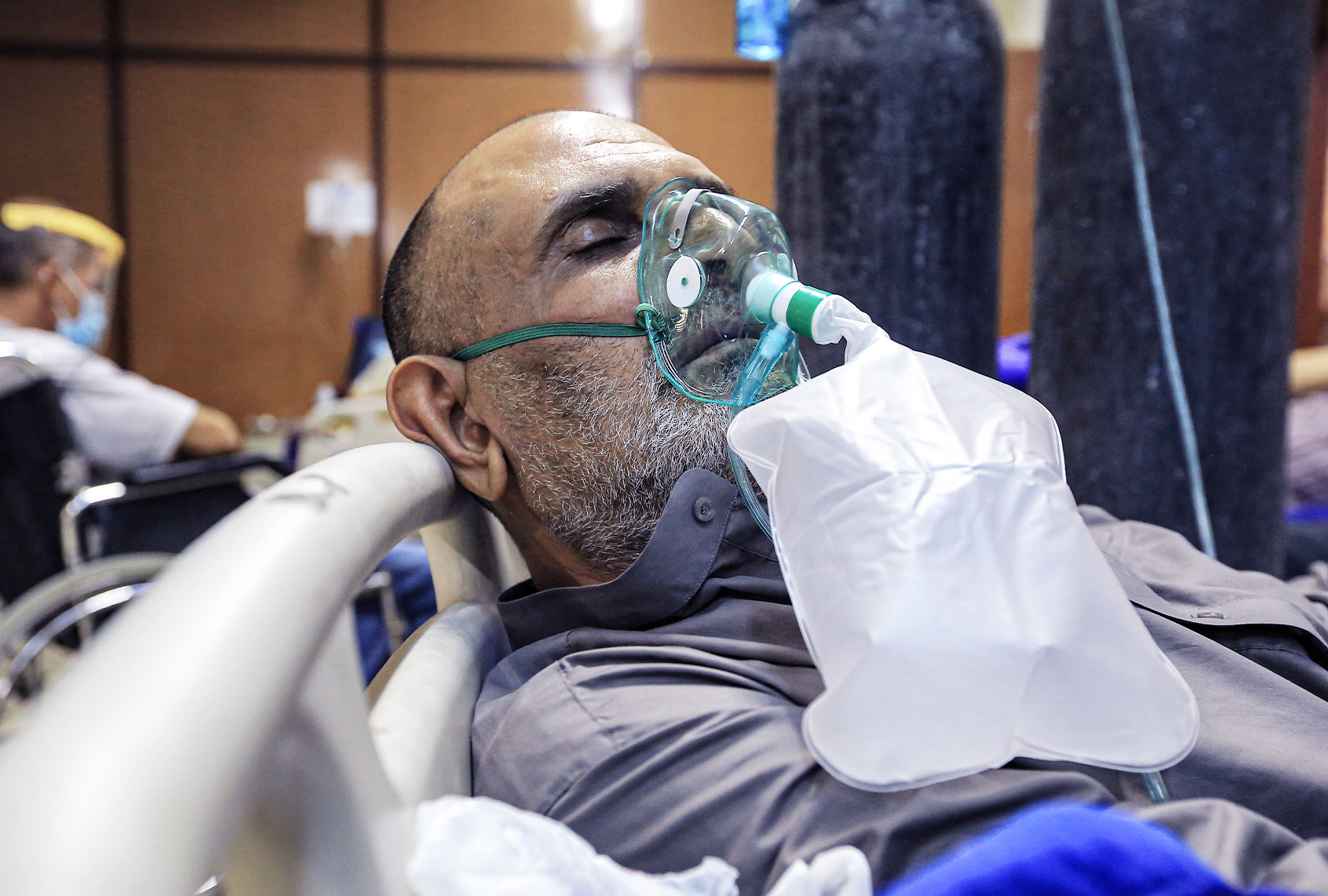 A coronavirus patient lies on a bed inside in a ward at Al-Ataa hospital. (Ameer Al Mohammedaw/picture alliance via Getty Images)
