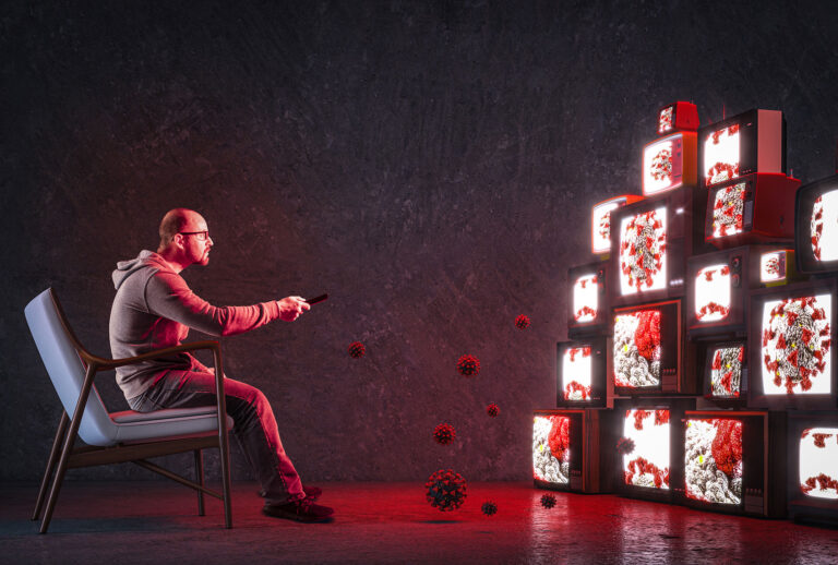 Man on an armchair watching many televisions that only broadcast news about COVID-19 (Getty Images/Tiero)