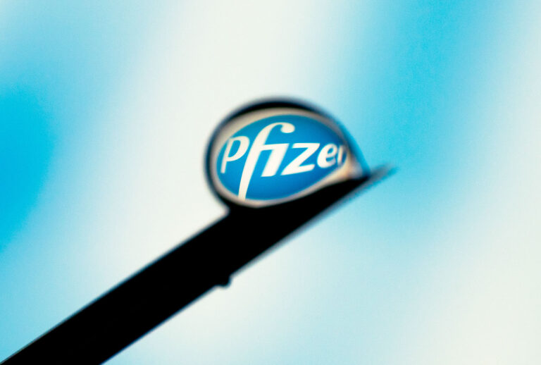 The Pfizer logo is seen reflected in a drop on a needle (Jaap Arriens/NurPhoto via Getty Images)