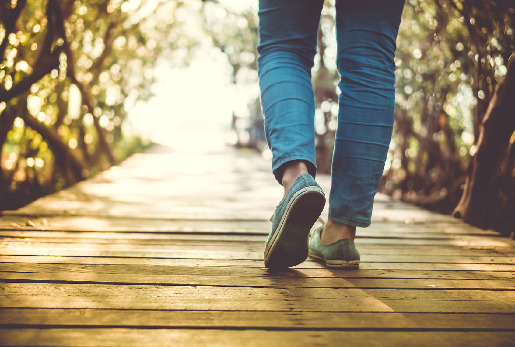 Low Section Of Woman Walking On Boardwalk During Sunny Day (Getty Images/Suwaree Tangbovornpichet/EyeEm)