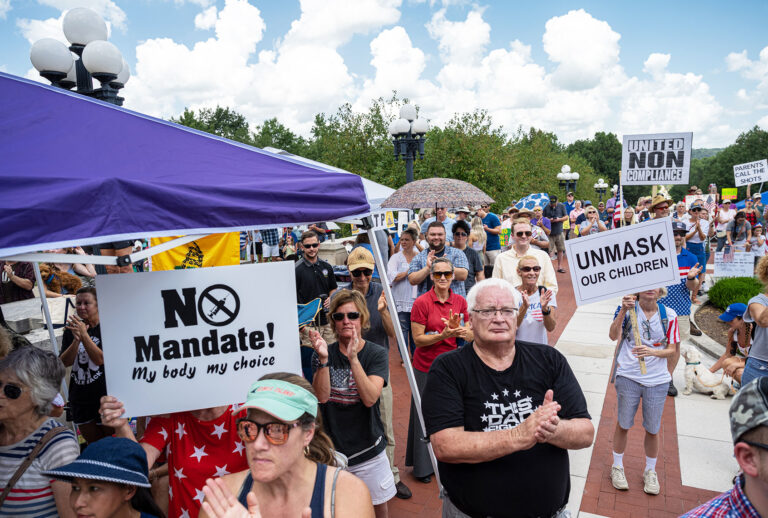 People clap, cheer, and display protest signs during the Kentucky Freedom Rally at the capitol building on August 28, 2021 in Frankfort, Kentucky. (Jon Cherry/Getty Images)