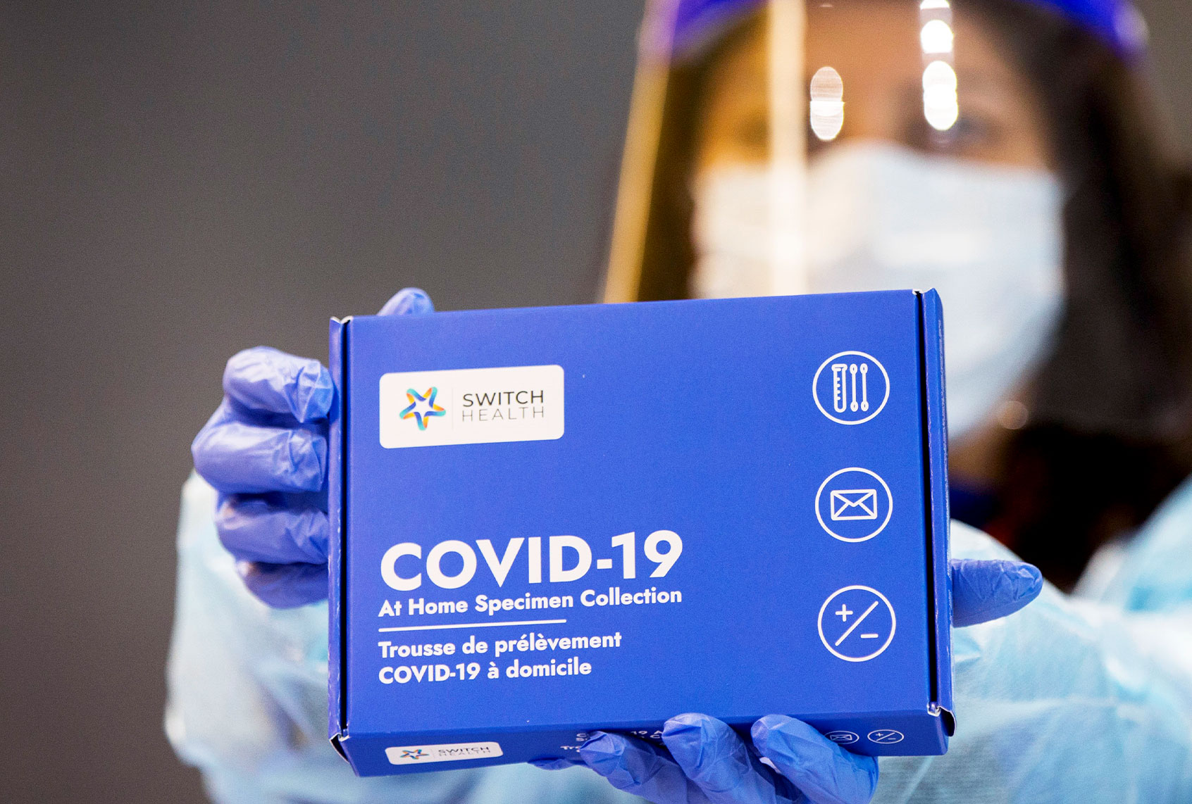 A medical worker shows a COVID-19 At-Home Specimen Collection kit (Xinhua/Zou Zheng via Getty Images)