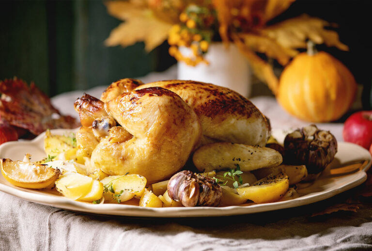 Baked chicken with potatoes and lemons on big ceramic dish, yellow autumn leaves and pumpkins as decorations over linen table cloth. Rustic style. (Natasha Breen/REDA&CO/Universal Images Group via Getty Images)