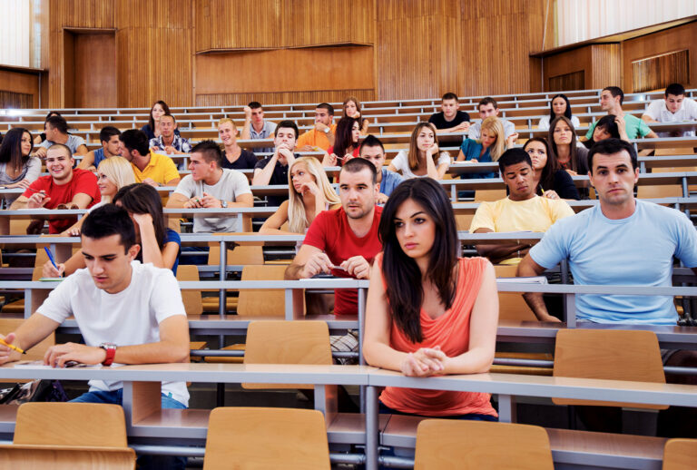 Large group of students at university lecture hall (Getty Images/skynesher)