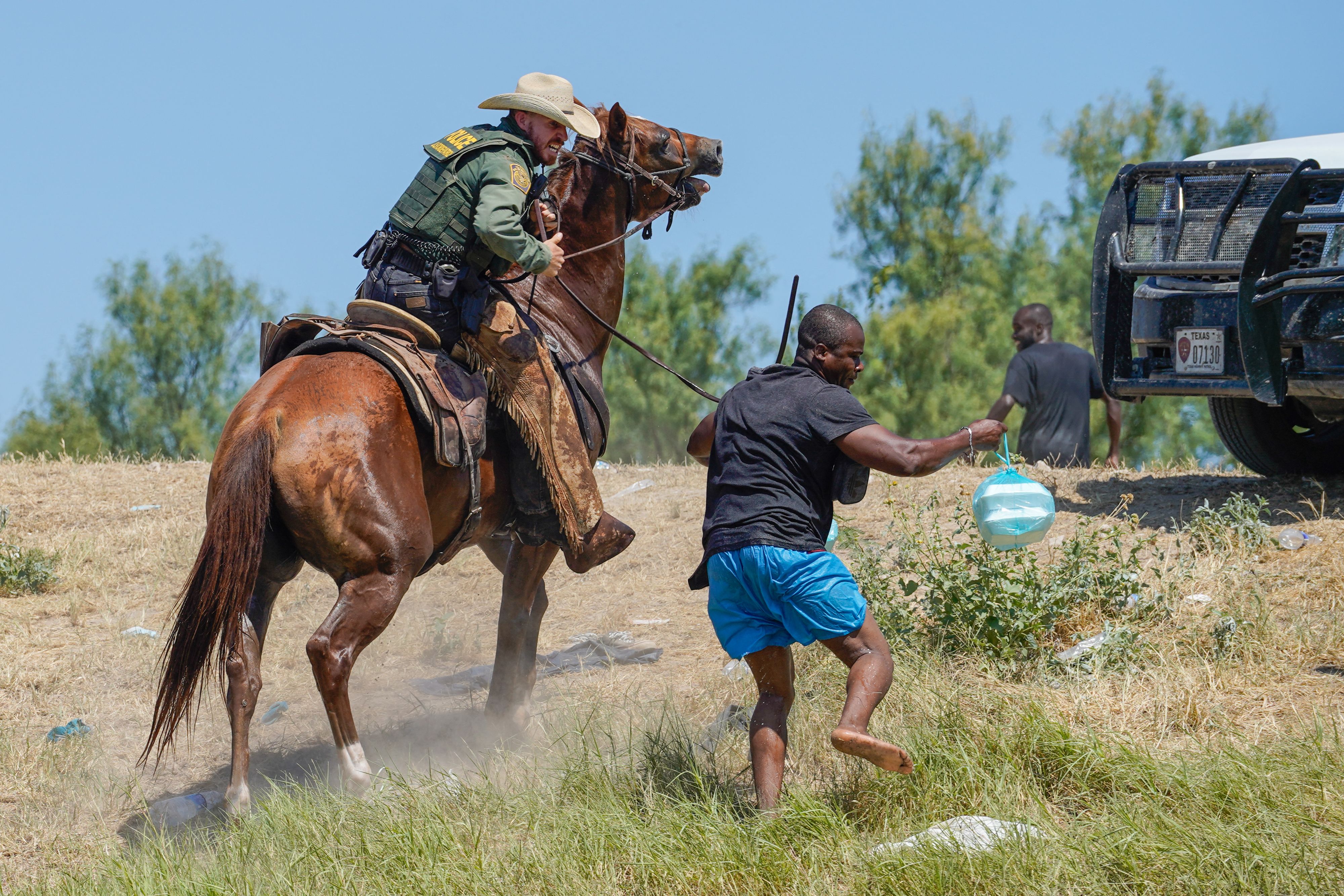 A United States Border Patrol agent on horseback uses the reins to try and stop a Haitian migrant from entering an encampment on the banks of the Rio Grande near the Acuna Del Rio International Bridge in Del Rio, Texas on September 19, 2021. (PAUL RATJE/AFP via Getty Images)