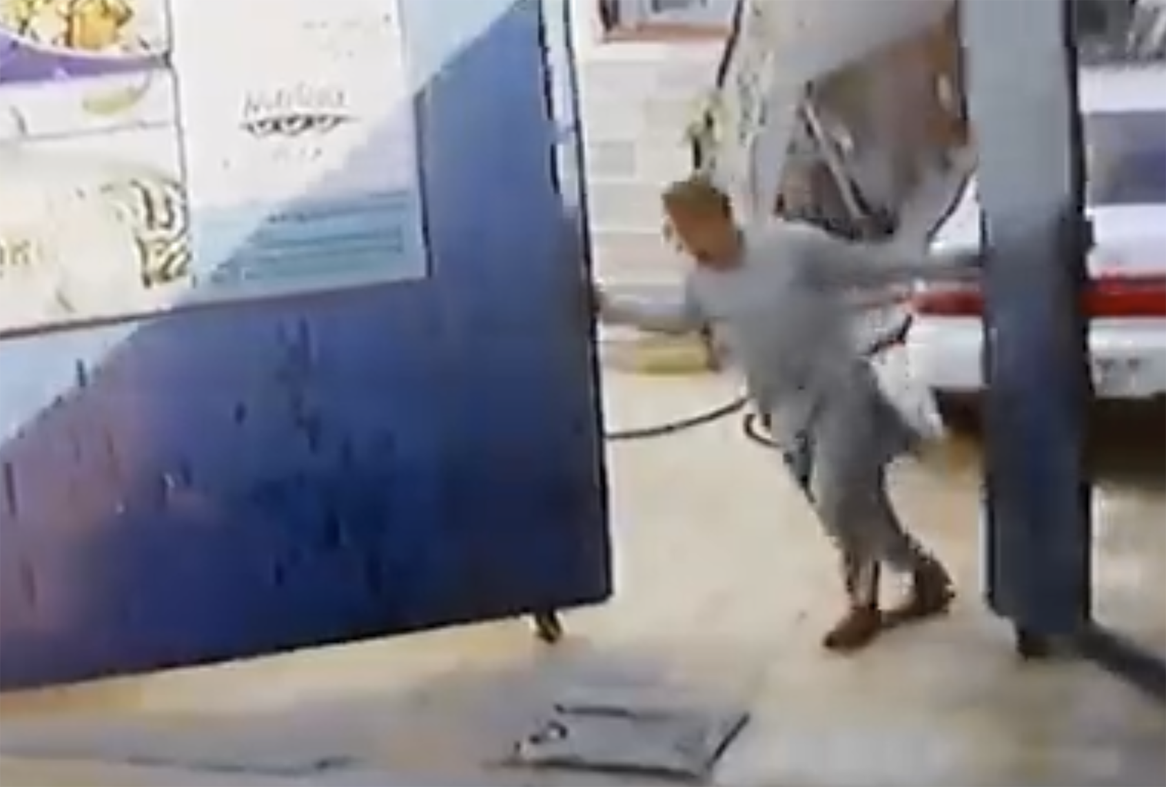In a frame from video obtained by The New York Times, a man closes a gate after pulling his car into a courtyard. (Screenshot via New York Times)