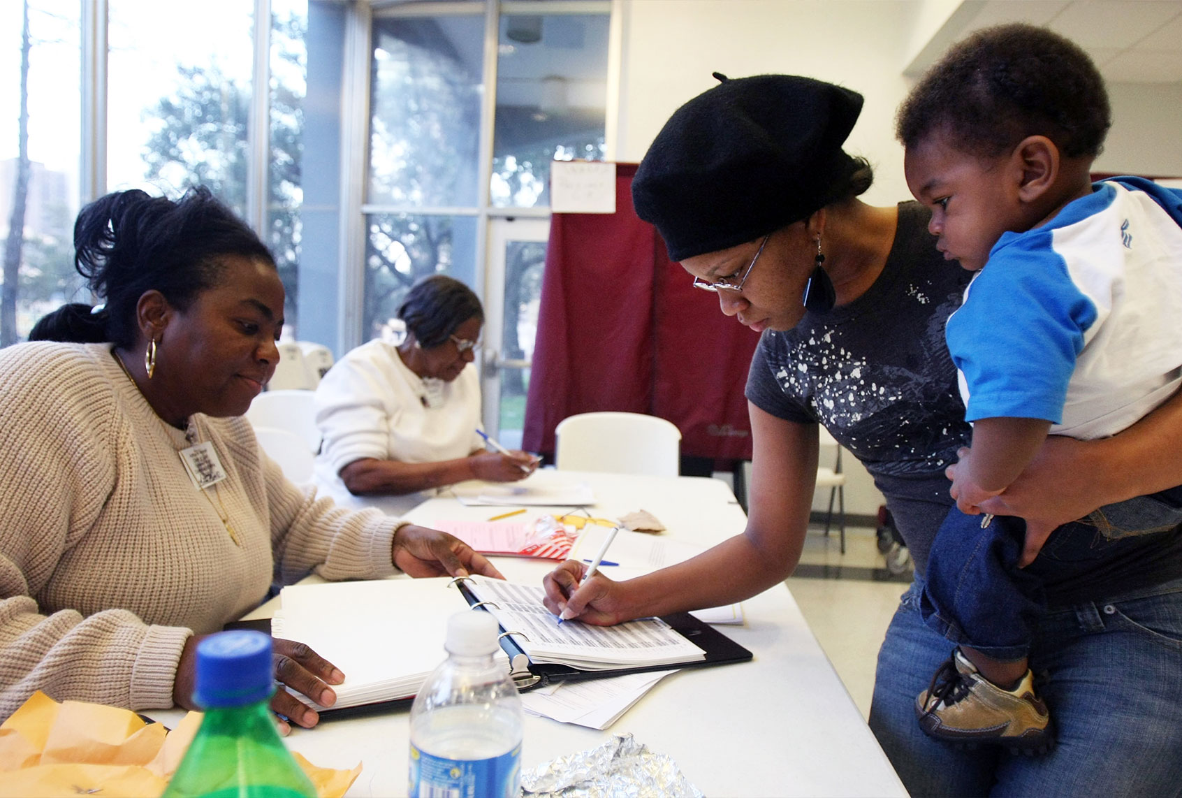 Poll worker looks on as a female voter is signing in during the state's presidential primary in New Orleans, Louisiana. (Mario Tama/Getty Images)