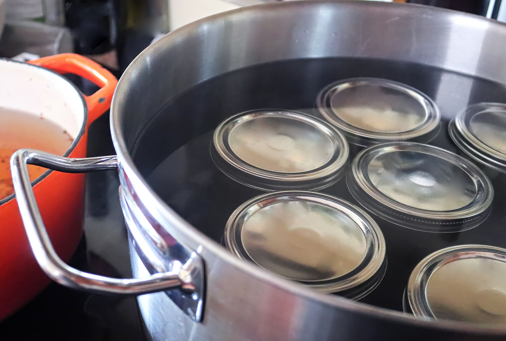 Pickling jars in a pot full of water (Getty Images/Akchamczuk)