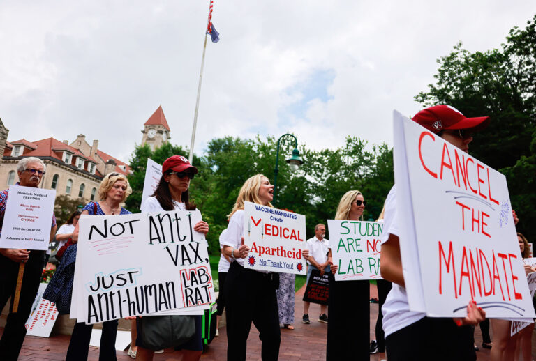 Protesters hold placards during the demonstration. Anti-vaxxers and anti-maskers gathered at Indiana University's Sample Gates to protest against mandatory Covid vaccinations IU is requiring for students, staff and faculty during the upcoming fall semester. (Jeremy Hogan/SOPA Images/LightRocket via Getty Images)