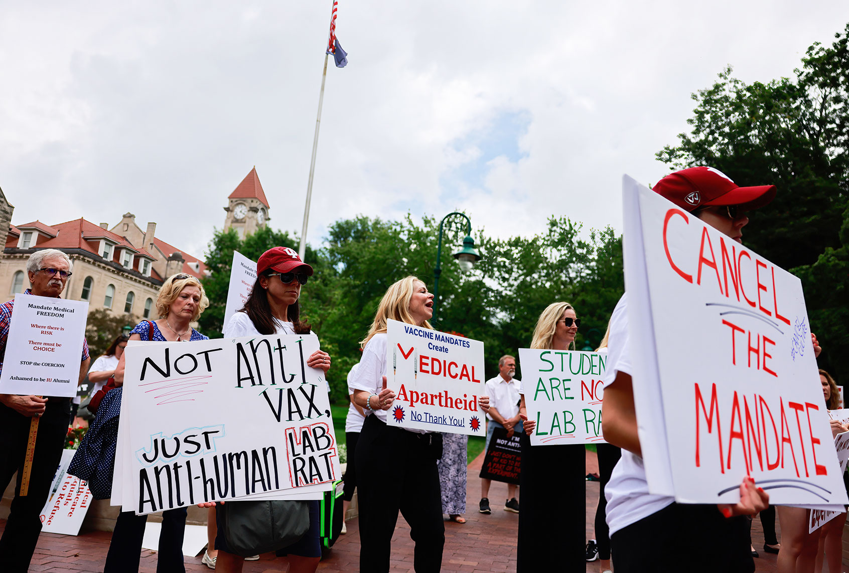 Protesters hold placards during the demonstration. Anti-vaxxers and anti-maskers gathered at Indiana University's Sample Gates to protest against mandatory Covid vaccinations IU is requiring for students, staff and faculty during the upcoming fall semester. (Jeremy Hogan/SOPA Images/LightRocket via Getty Images)