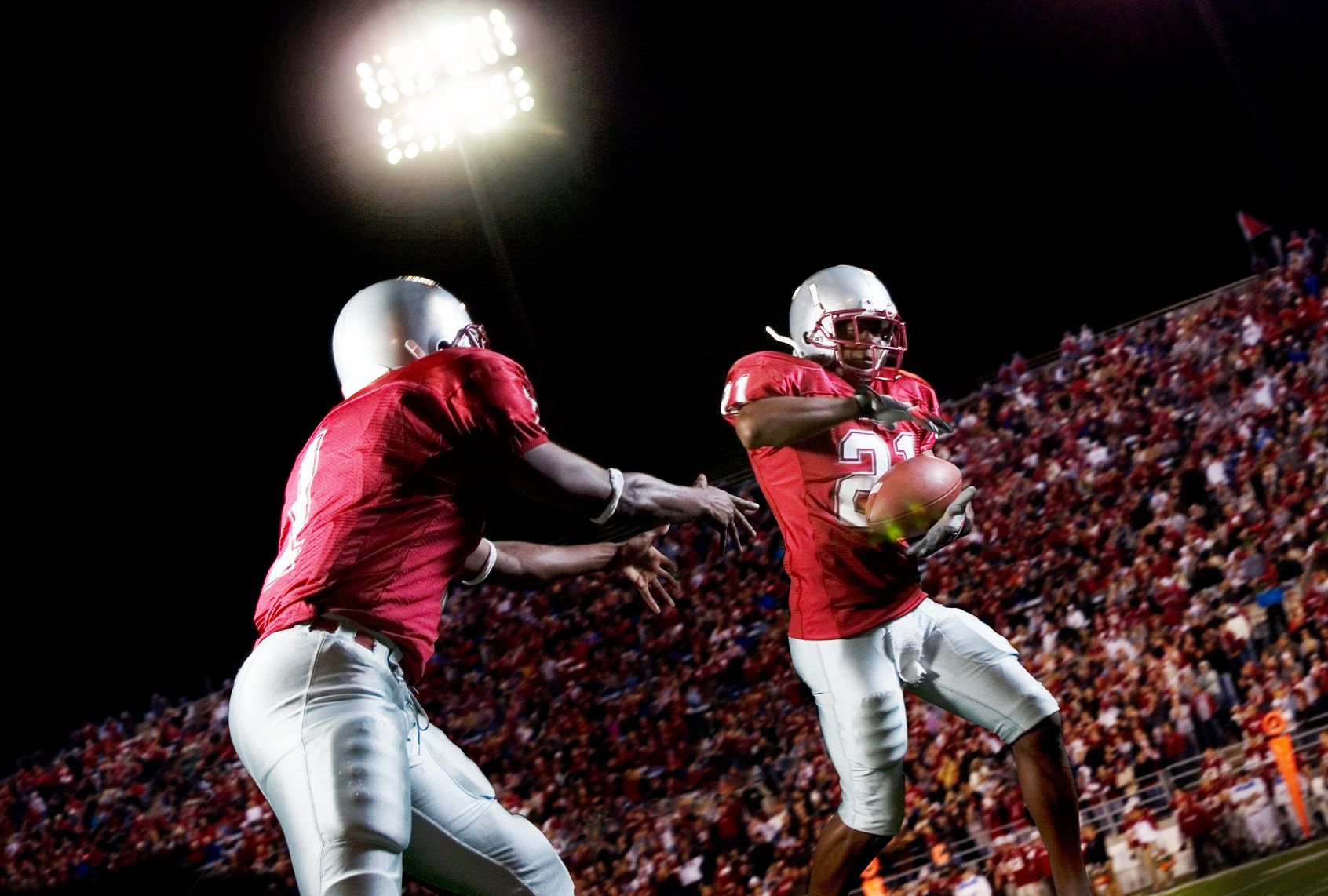 Football players passing football (Getty Images/Pete Saloutos)
