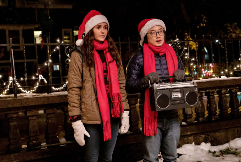 Nina Dobrev and Jimmy O. Yang caroling in "Love Hard" (Bettina Strauss/Netflix)