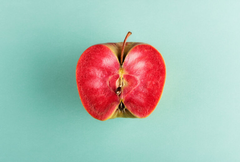 Sliced in half apple fruit with vivid red flesh (Getty Images/Photology1971)
