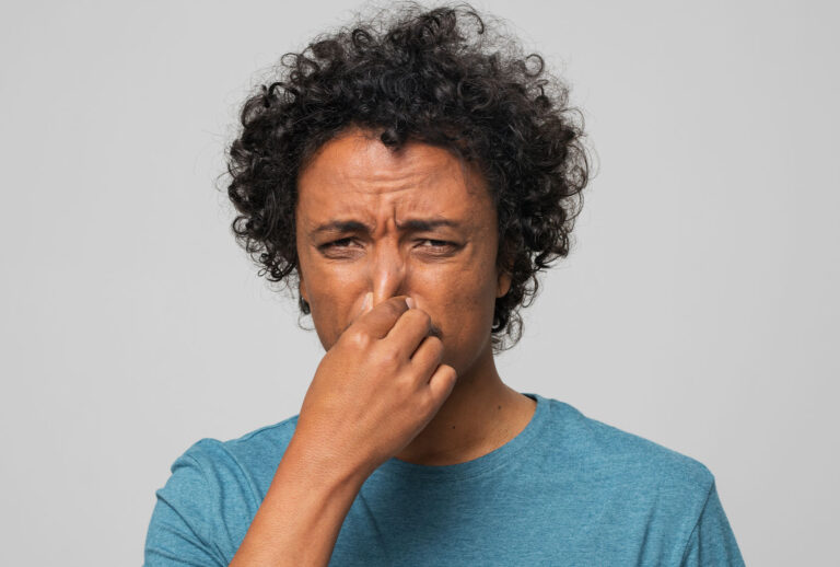 Young man holding nose (Getty Images/simonkr)